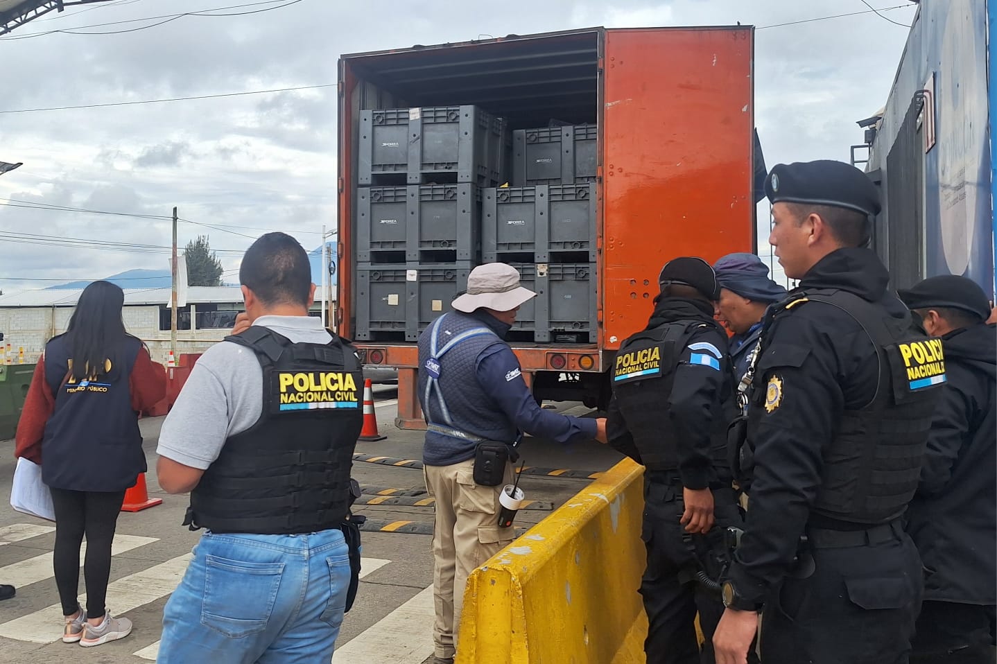 Agentes antinarcóticos inspeccionan un furgón donde iban los paquetes con marihuana ocultos como mensajería, durante un operativo en la ruta Interamericana. (Foto Prensa Libre: PNC)
