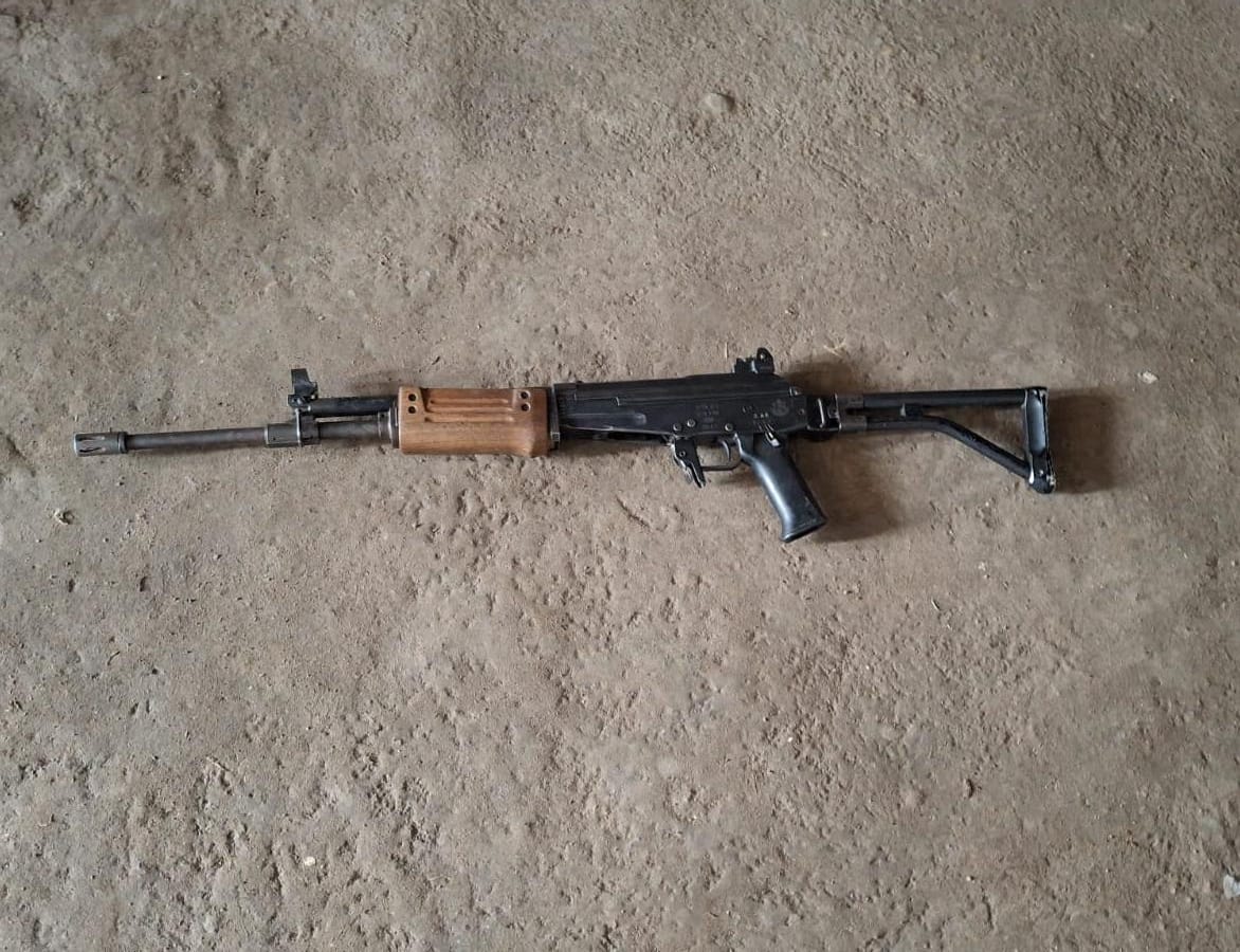 Investigadores de la PNC embalan un fusil localizado durante el allanamiento efectuado en la zona 25 capitalina. (Foto Prensa Libre: PNC)