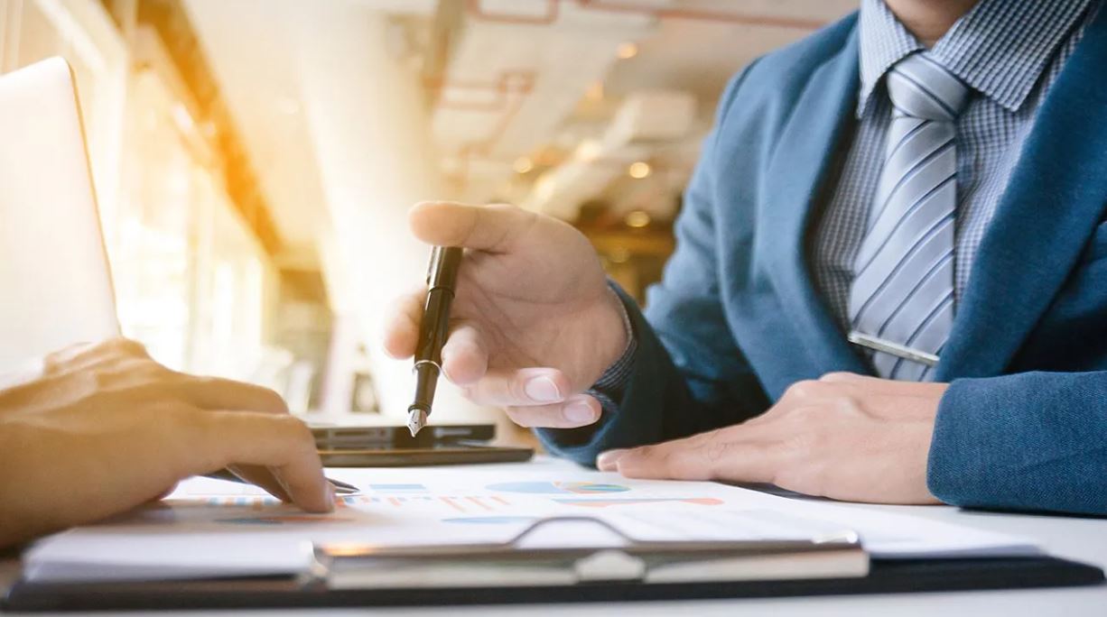 Ley de competencia personas en reunión revisando papelería