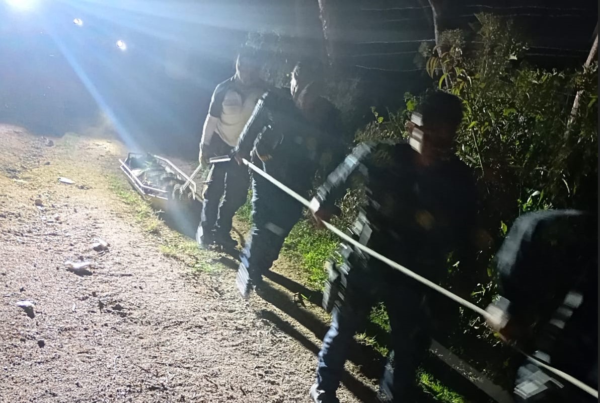 Socorristas trasladan el cuerpo de la mujer hallado enterrado en la finca El Tecolote, San Pedro Ayampuc, hasta la carretera, donde se efectuaron las diligencias. (Foto Prensa Libre: CVB)