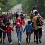 Migrantes adultos y niños migrantes caminando por las carreteras