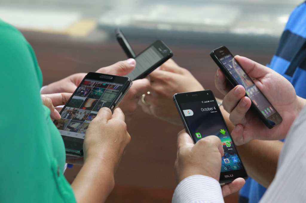 Imagen de referencia: varias personas sosteniendo sus teléfonos móviles, relacionada con la portabilidad numérica en Guatemala.