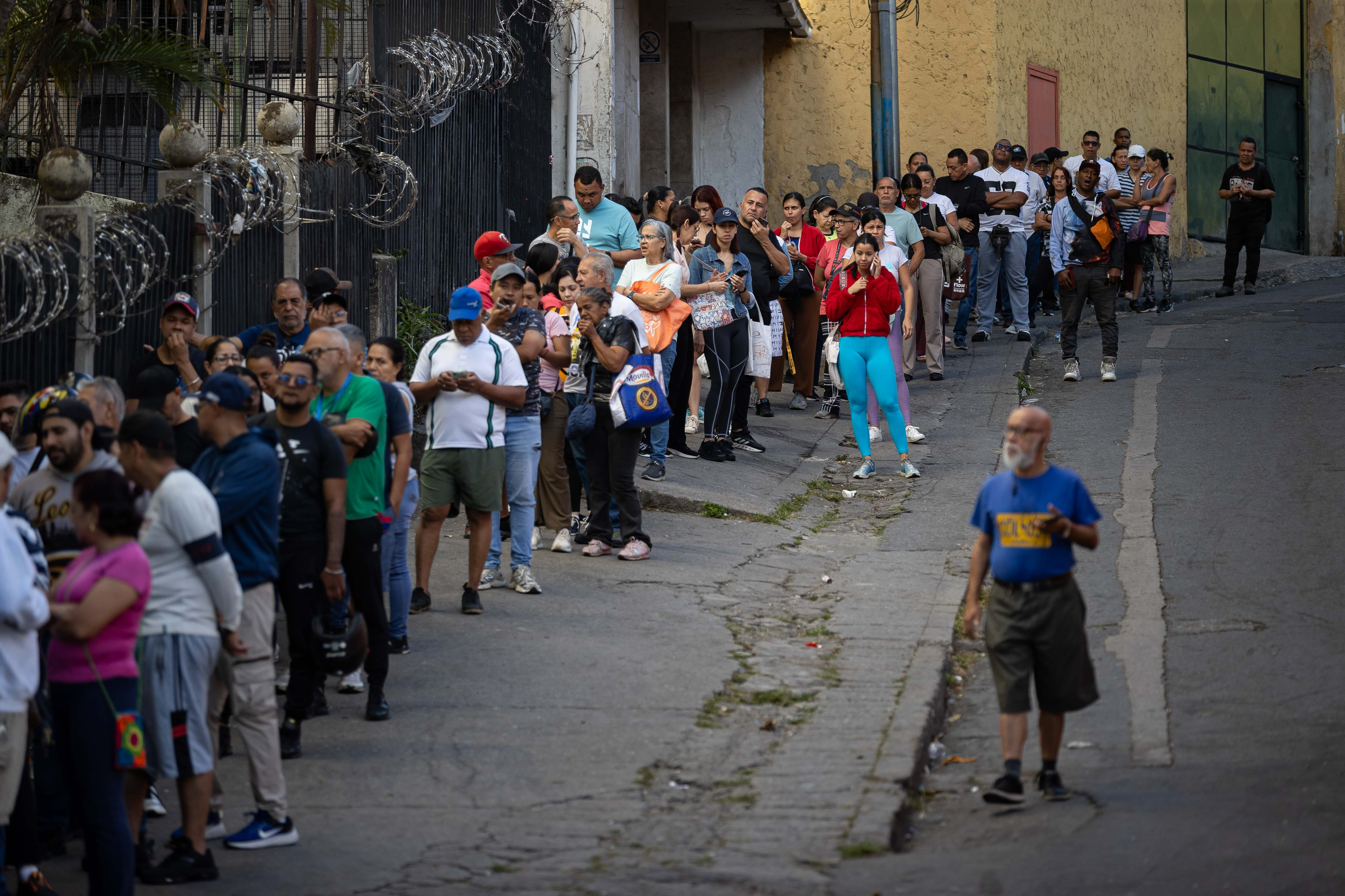 Personas hacen fila para ingresar en un supermercado este domingo, en Caracas (Venezuela). Caracas amaneció ralentizada, con calles vacías, muy poca circulación de vehículos y comercios con largas filas de compradores, un día después del ataque de EE.UU y de la captura del presidente Nicolás Maduro y de su esposa, Cilia Flores. (Foto Prensa Libre: EFE)