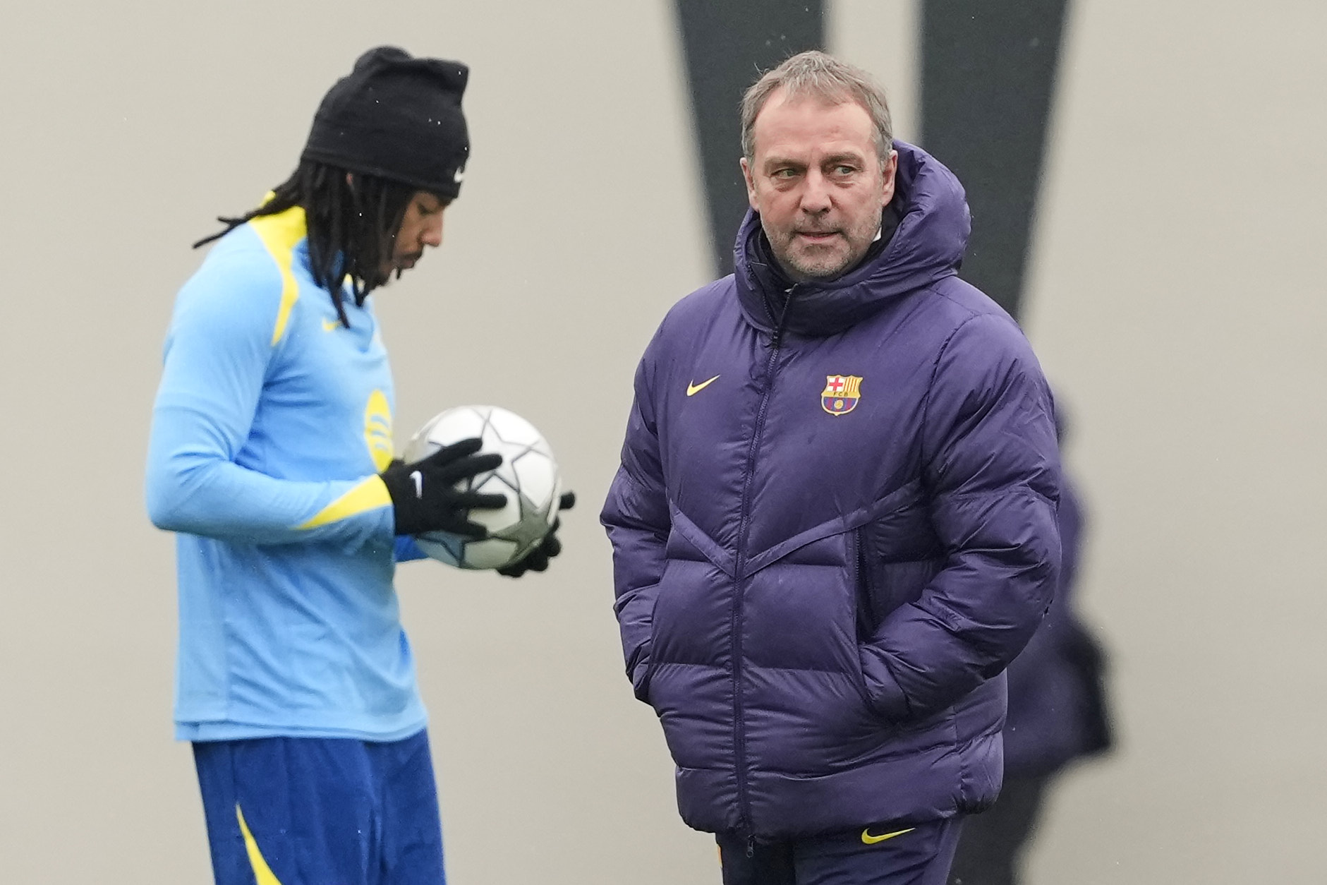 GRAFCAT7304. SANT JOAN DESPÍ (BARCELONA) (ESPAÑA), 27/01/2026.-El defensa francés del FC Barcelona, Jules Kunde (i) y el técnico alemán, Hansi Flick (d), durante el entrenamiento que realiza la plantilla barcelonista en la Ciudad Deportiva Joan Gamper, para preparar el partido correspondiente a la última jornada de la fase liga de la Liga de Campeones que disputurán mañana ante el Copenhague en el  Spotify Camp Nou.EFE/ Alejandro García