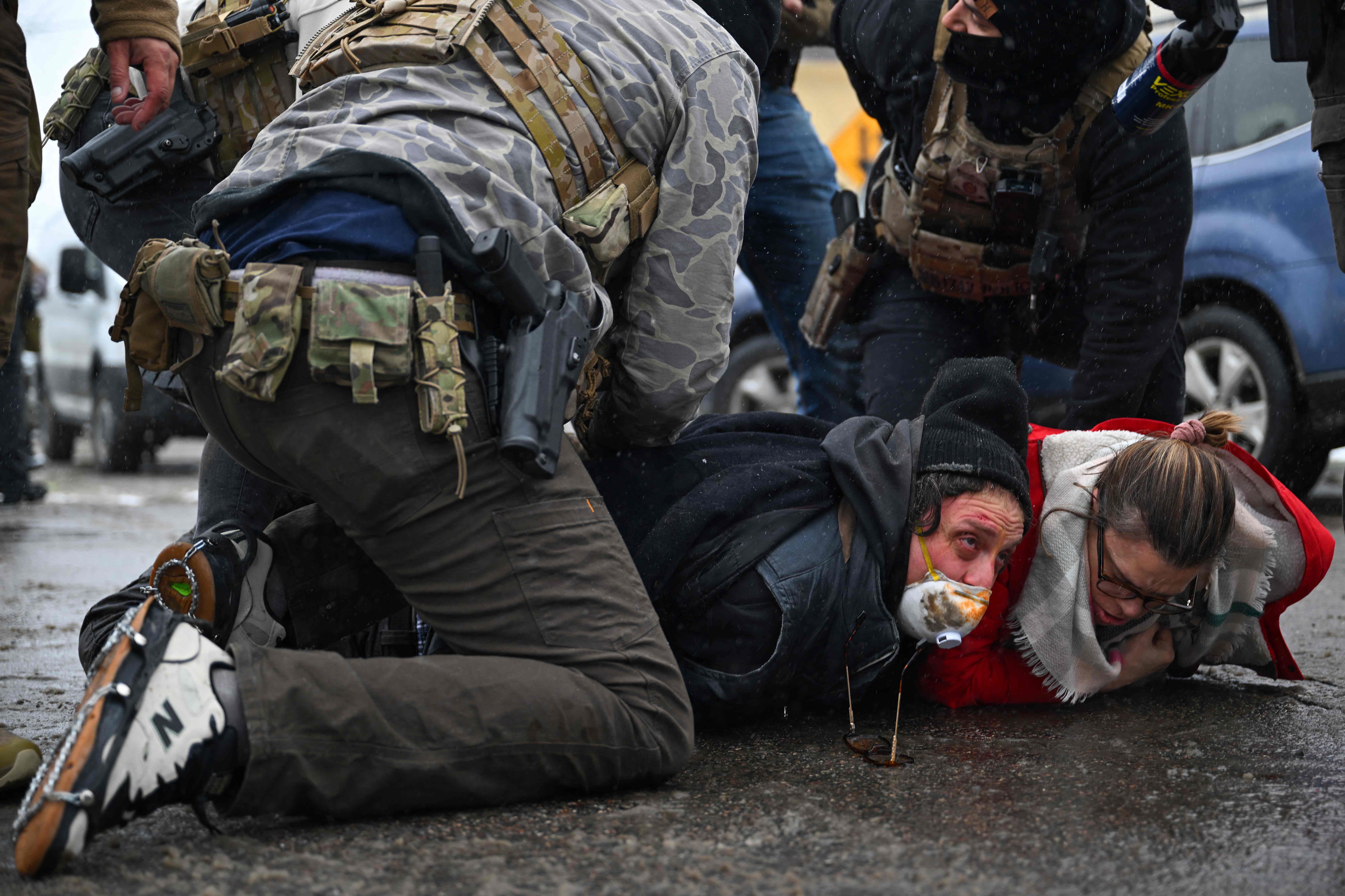 MINNEAPOLIS, MINNESOTA - JANUARY 21: U.S. Border Patrol agents detain bystanders during a confrontation in an intersection on January 21, 2026 in Minneapolis, Minnesota. A reported 3,000 Department of Homeland Security federal agents have been deployed to the state, with more on the way, amid the Trump administration's major crackdown on immigration enforcement.   Brandon Bell/Getty Images/AFP (Photo by Brandon Bell / GETTY IMAGES NORTH AMERICA / Getty Images via AFP)