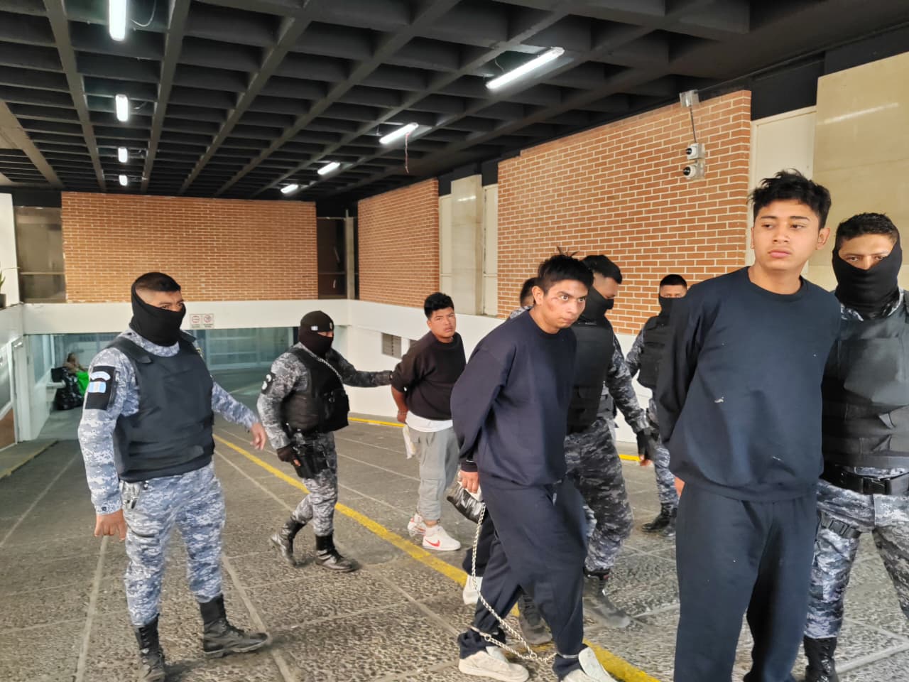 Agentes de la PNC trasladan a los tres pandilleros capturados en Chinautla hacia el centro preventivo para varones, zona 18, tras su detención por el ataque a una subestación policial. (Foto Prensa Libre)