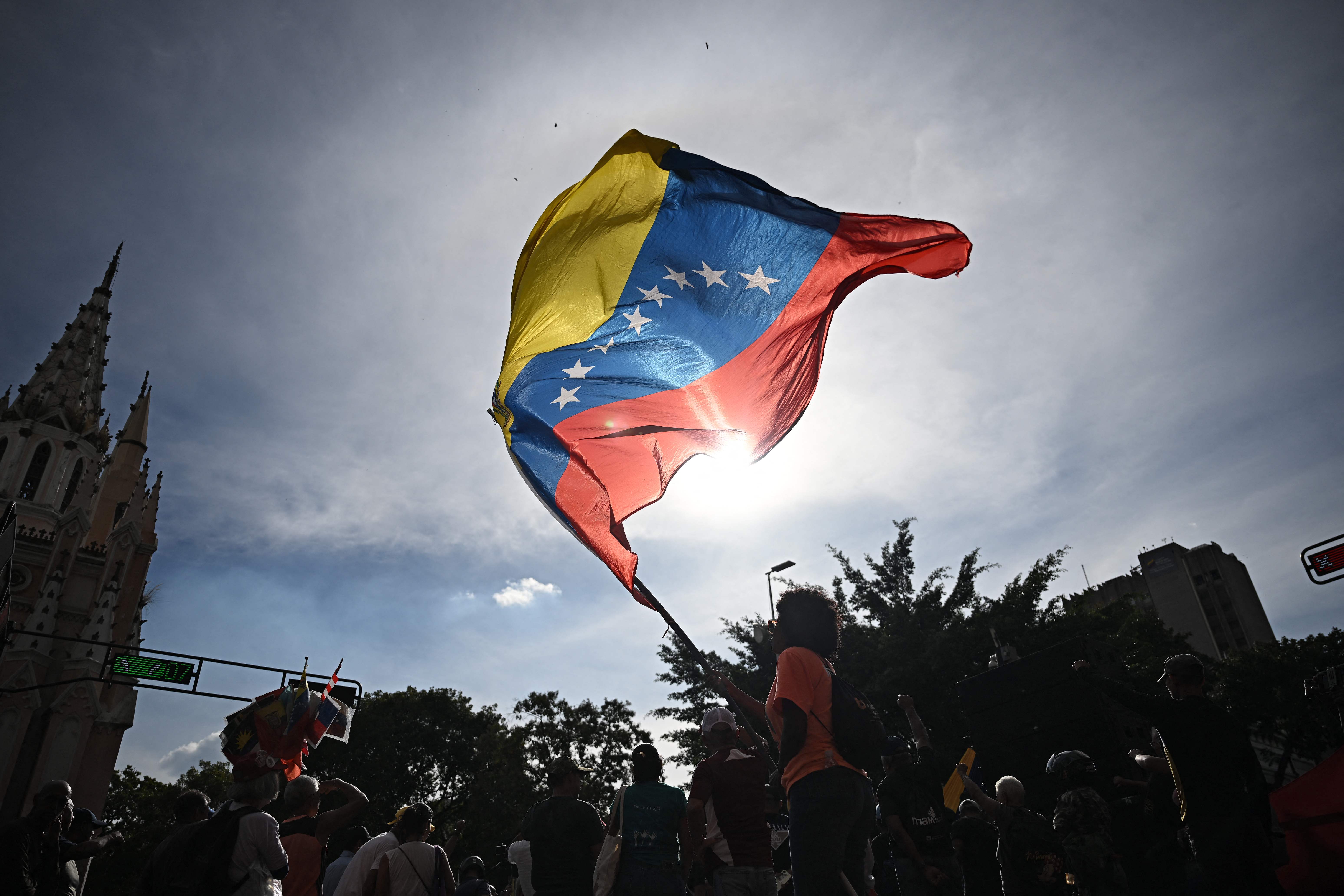 Venezolanos ondearon banderas en Caracas después de que las fuerzas estadounidenses capturaran a Nicolás Maduro.  (Foto Prensa Libre: Federico PARRA / AFP)