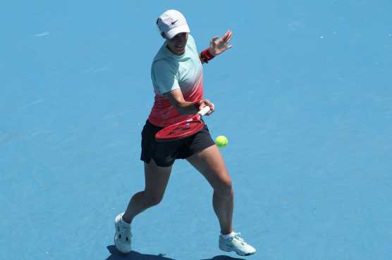 Ukraine's Anhelina Kalinina hits a return to China's Wang Xinyu during their women's singles match on day three of the Australian Open tennis tournament in Melbourne on January 20, 2026. (Photo by IZHAR KHAN / AFP) / -- IMAGE RESTRICTED TO EDITORIAL USE - STRICTLY NO COMMERCIAL USE --
