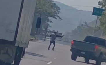 Un atacante desciende de una camioneta blanca y dispara contra el piloto de un vehículo en plena ruta al Pacífico, según se observa en un video grabado por automovilistas. (Foto Prensa Libre: Captura de pantalla)