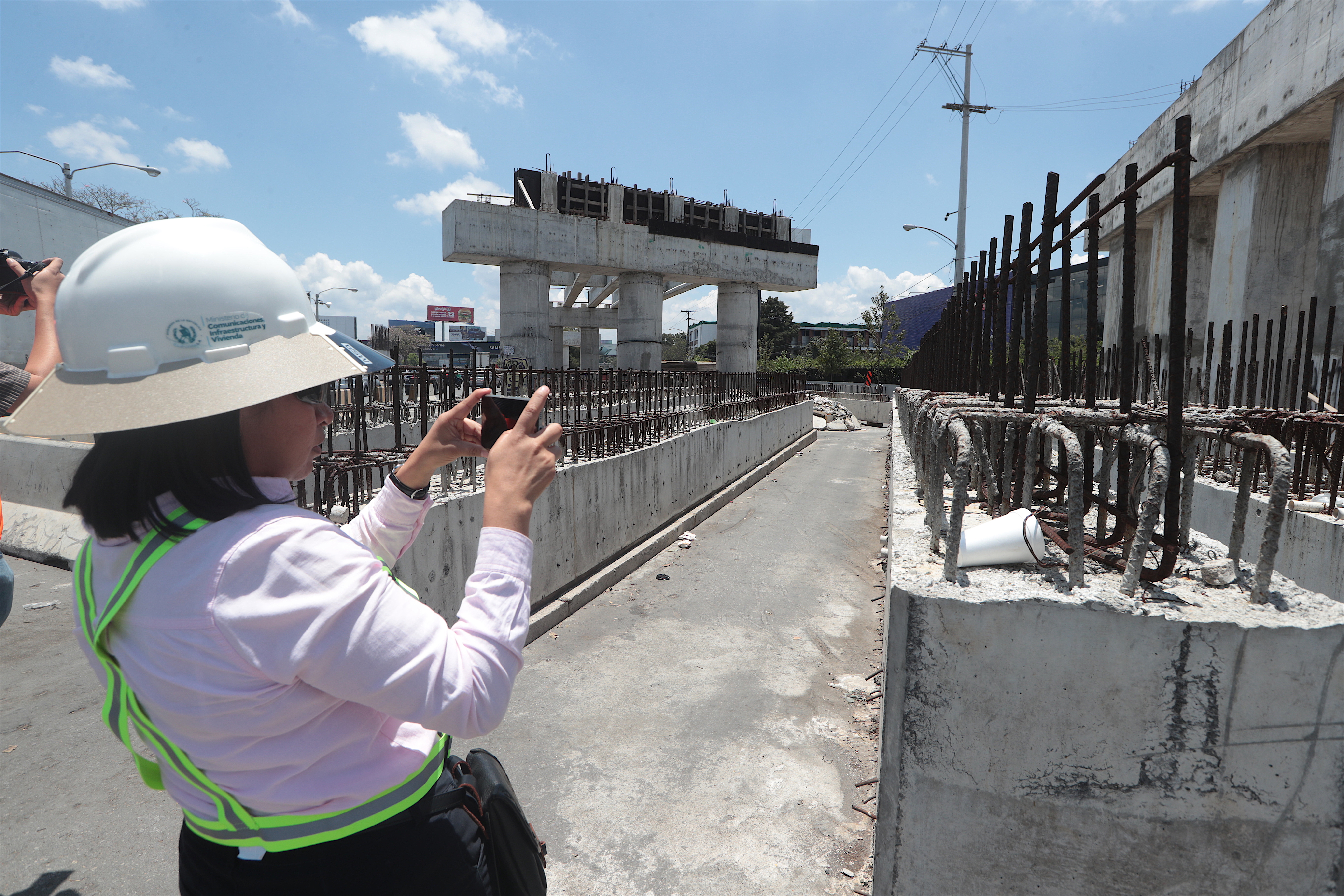 Ingeniera civil evalúa obra de paso a desnivel durante estudios de ingeniería vial en Guatemala.