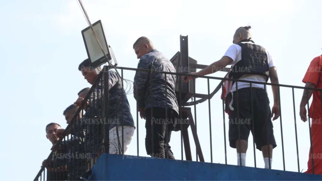 Reclusos exhiben a guardias penitenciarios retenidos como rehenes durante un motín en el centro penitenciario Renovación 1.