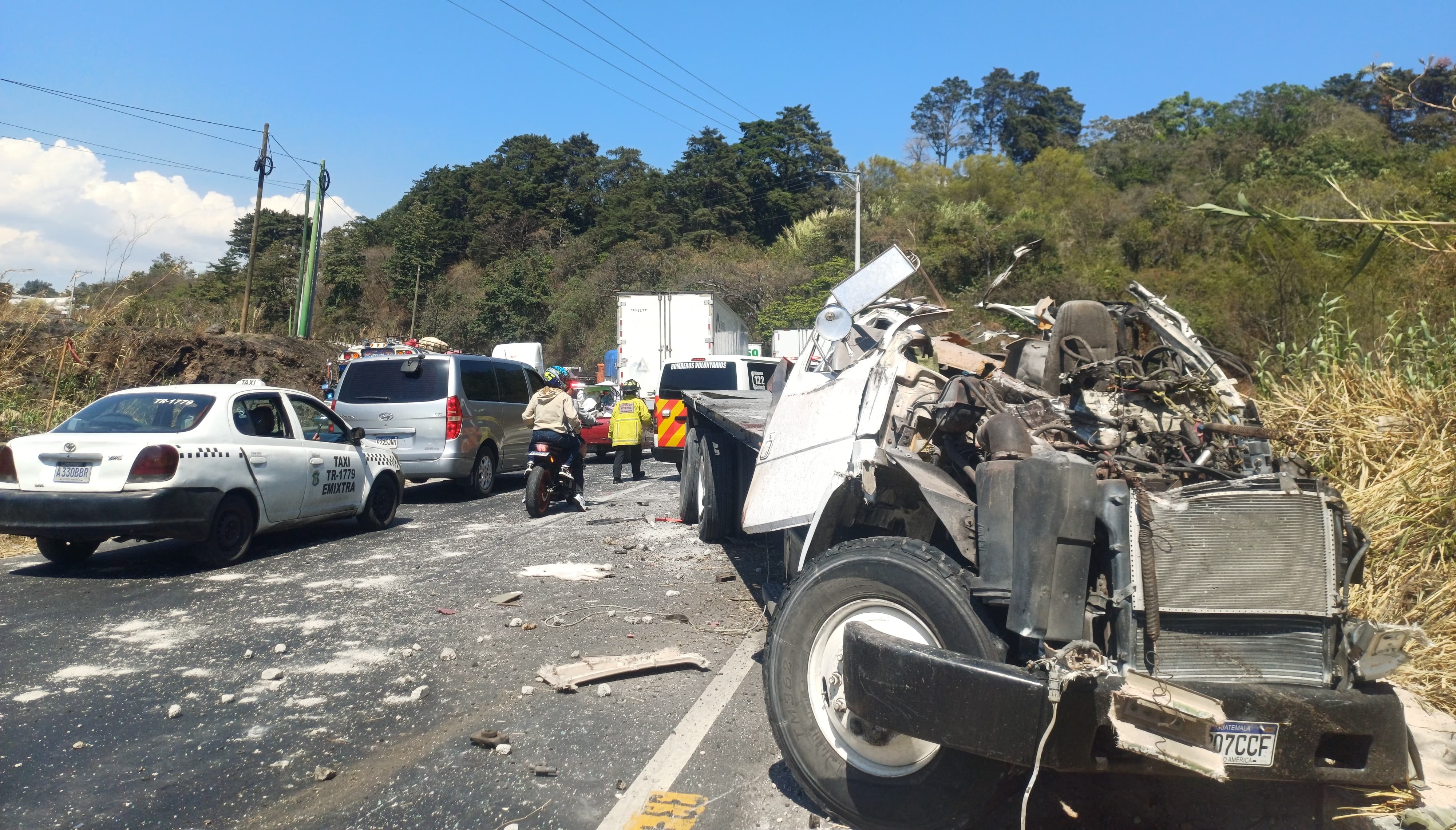 Un camión y una motocicleta quedan destruidos tras el accidente ocurrido en el kilómetro 33.5 de la carretera a El Salvador, en la Vuelta del Chilero, donde murieron dos personas y el paso hacia la capital fue cerrado. (Foto Prensa Libre: PMT de Fraijanes)