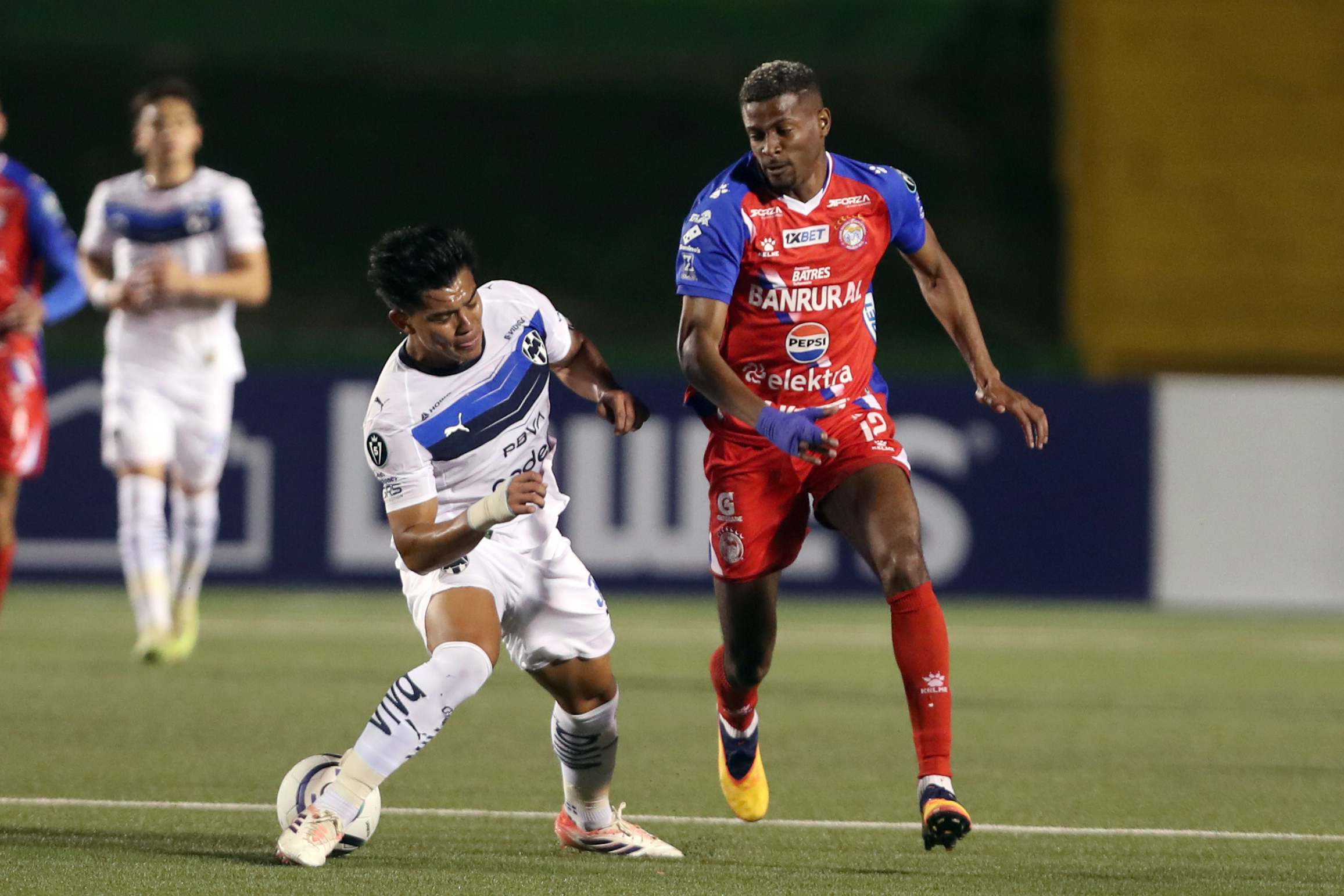 AME2107. CIUDAD DE GUATEMALA (GUATEMALA), 04/02/2026.- Derrickson Quirós de Xelajú MC (d) disputa el balón con César Bustos de Monterrey (i) este miércoles, en un partido por la Copa de Campeones de Concacaf entre Xelajú MC y Monterrey en el estadio Cementos Progreso, en Ciudad de Guatemala (Guatemala). EFE / Fernando Ruiz