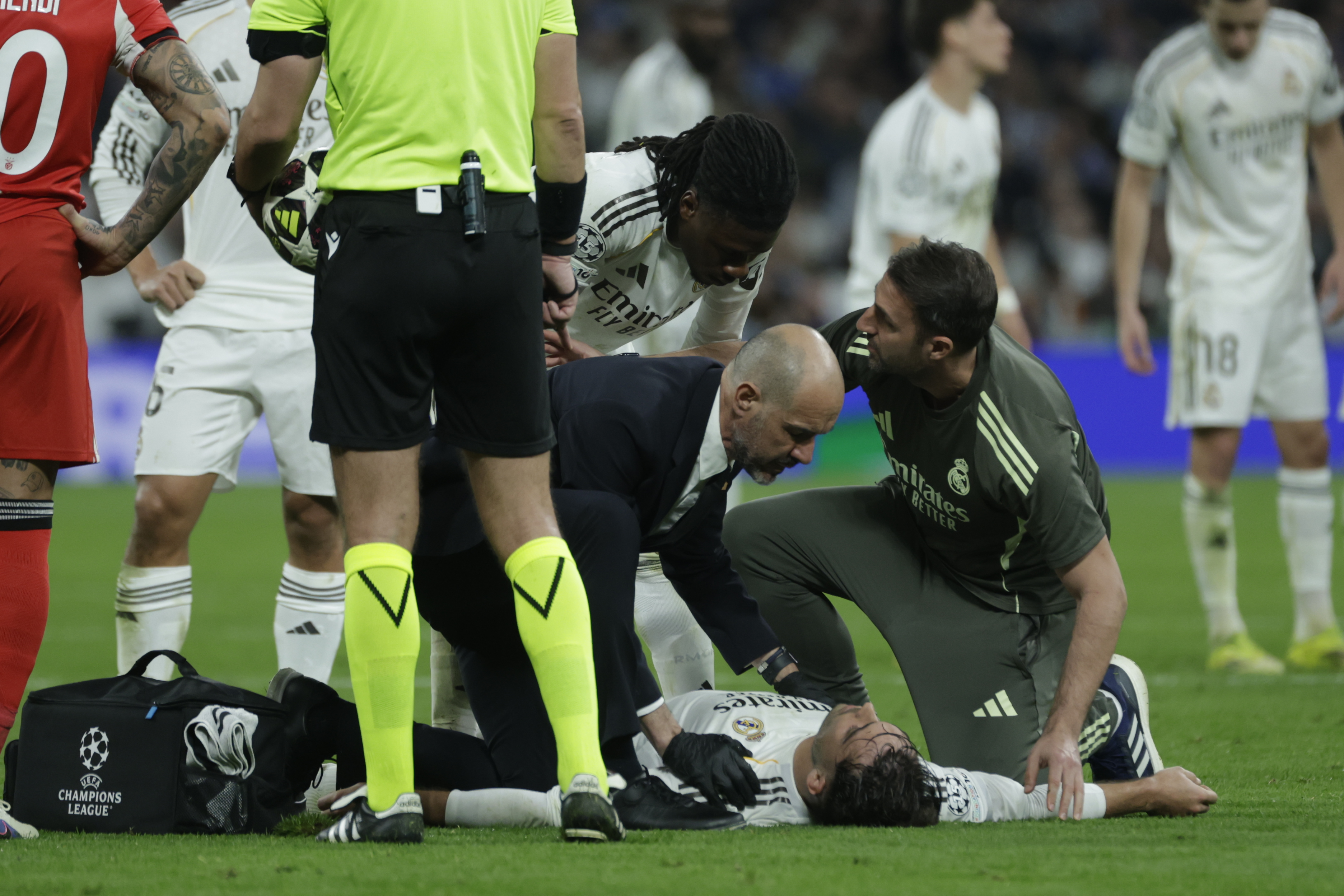 MADRID, 25/02/2026.- El defensa del Real Madrid Raúl Asencio (en el suelo) es atendido durante el partido de vuelta de la fase de acceso a los octavos de la Liga de Campeones que Real Madrid y Benfica disputan este miércoles en el estadio Santiago Bernabéu. EFE/Juanjo Martín