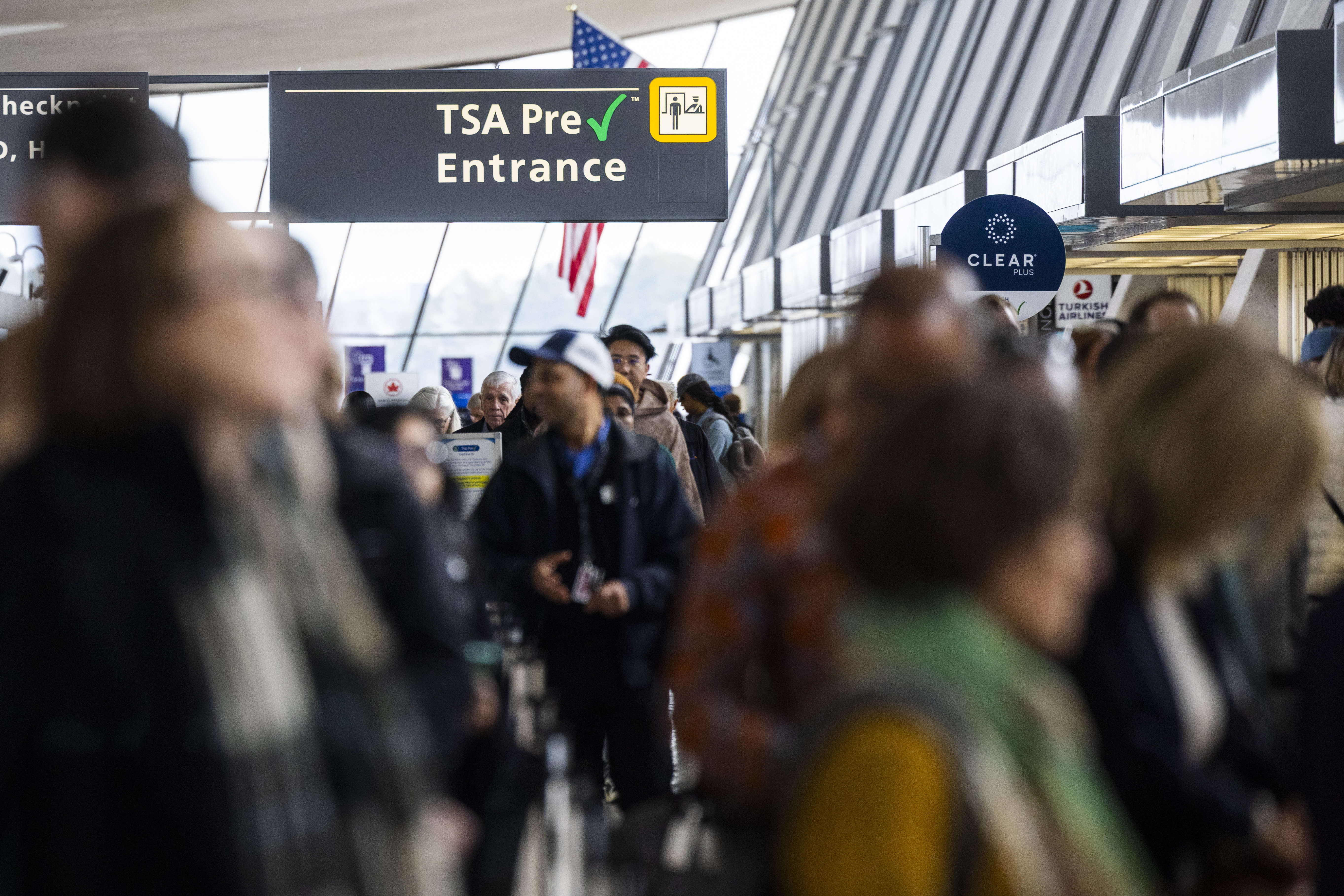Pasajeros en fila en carril TSA PreCheck en aeropuerto Washington Dulles durante controles de seguridad