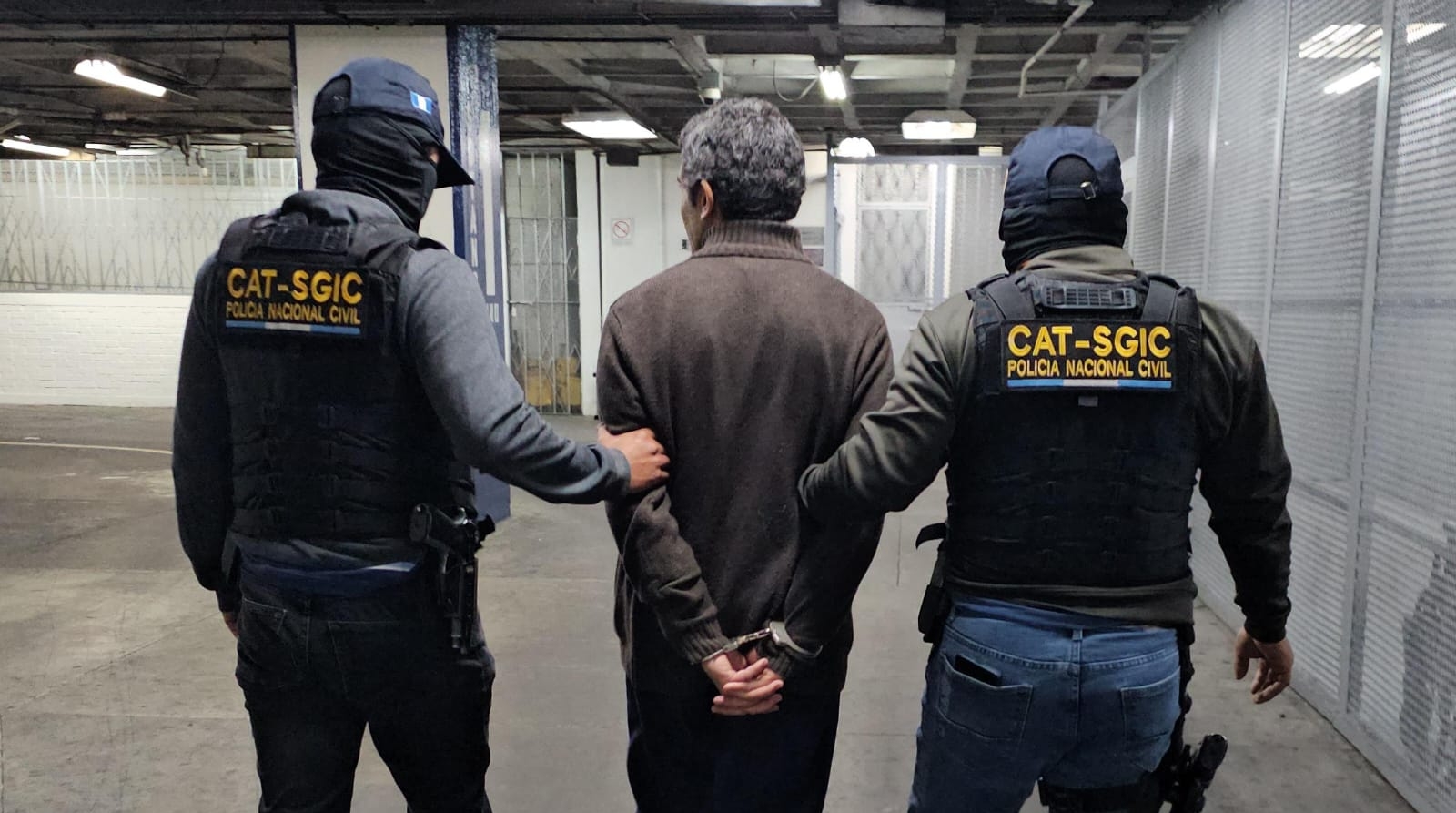 Agentes trasladan bajo custodia a Eduardo “V”, alias “Edgardo Luis Pérez”, hacia la Torre de Tribunales, donde será puesto a disposición de juez competente para iniciar el proceso de extradición.  (Foto Prensa Libre: PNC)