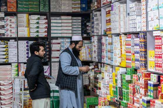 This photograph taken on February 9, 2026 shows an Afghan man purchasing medicines at a pharmacy in Kabul. Afghanistan's decision to overhaul its medicine market was meant to improve quality and boost domestic production, but industry specialists say the swift changes have led to a litany of problems. (Photo by Wakil KOHSAR / AFP)