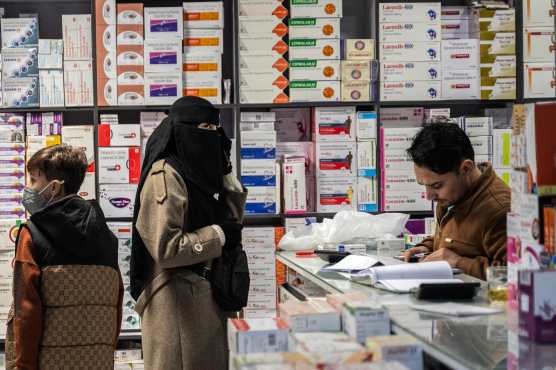 This photograph taken on February 9, 2026 shows an Afghan woman purchasing medicines at a pharmacy in Kabul. Afghanistan's decision to overhaul its medicine market was meant to improve quality and boost domestic production, but industry specialists say the swift changes have led to a litany of problems. (Photo by Wakil KOHSAR / AFP)