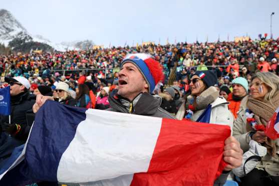 A fan waves France's flag while watching the women's biathlon 4x6km relay event during the Milano Cortina 2026 Winter Olympic Games at the Anterselva Biathlon Arena (Sudtirol Arena) in Anterselva (Val Pusteria) on February 18, 2026. (Photo by Odd ANDERSEN / AFP)