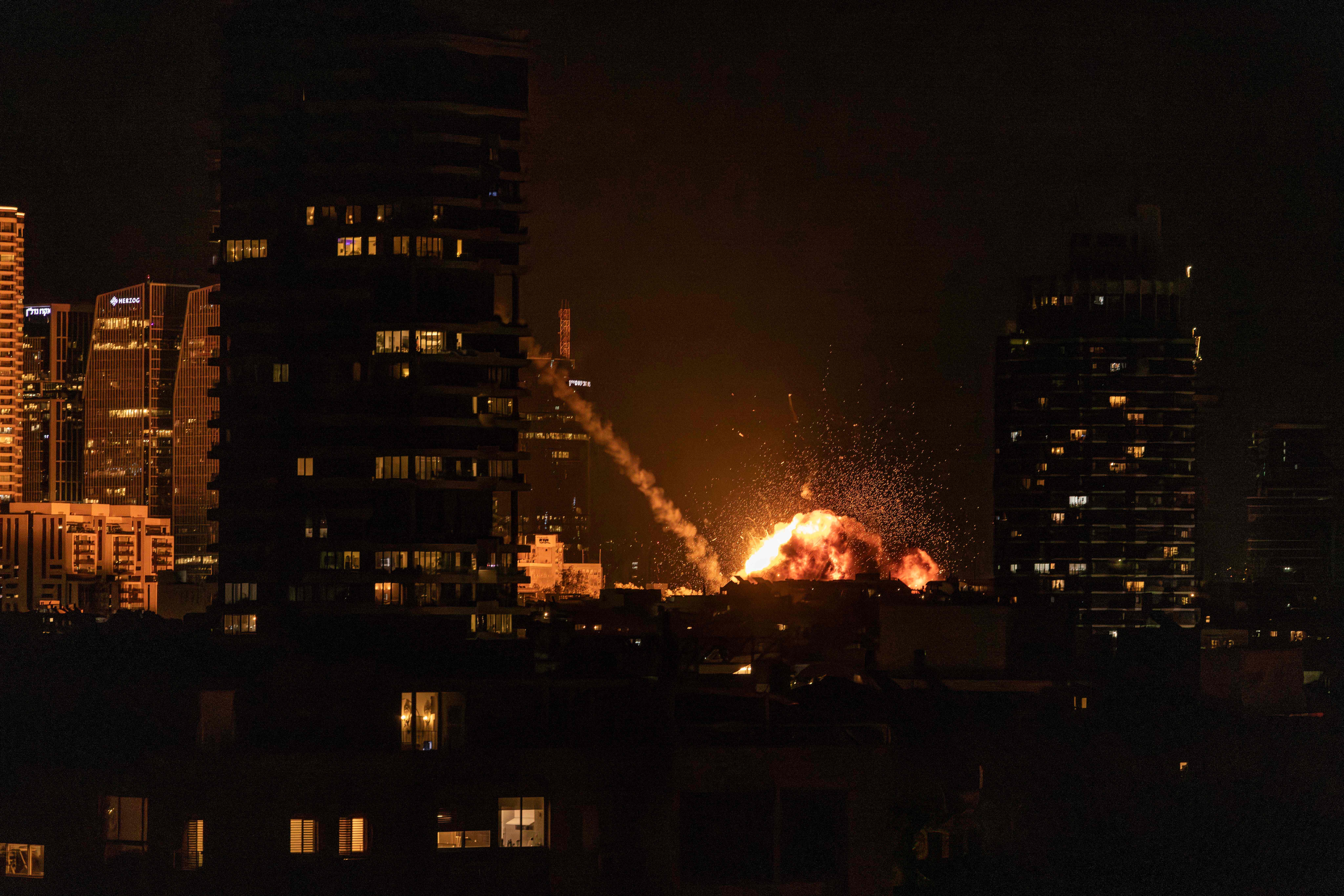 A fireball lights the sky following a missile strike on Tel Aviv on February 28, 2026. The United States and Israel launched strikes against Iran on February 28, with Israel's public broadcaster reporting that the Iranian supreme leader had been targeted, as the Islamic republic retaliated with barrages of missiles at Gulf states and Israel. (Photo by JOHN WESSELS / AFP)