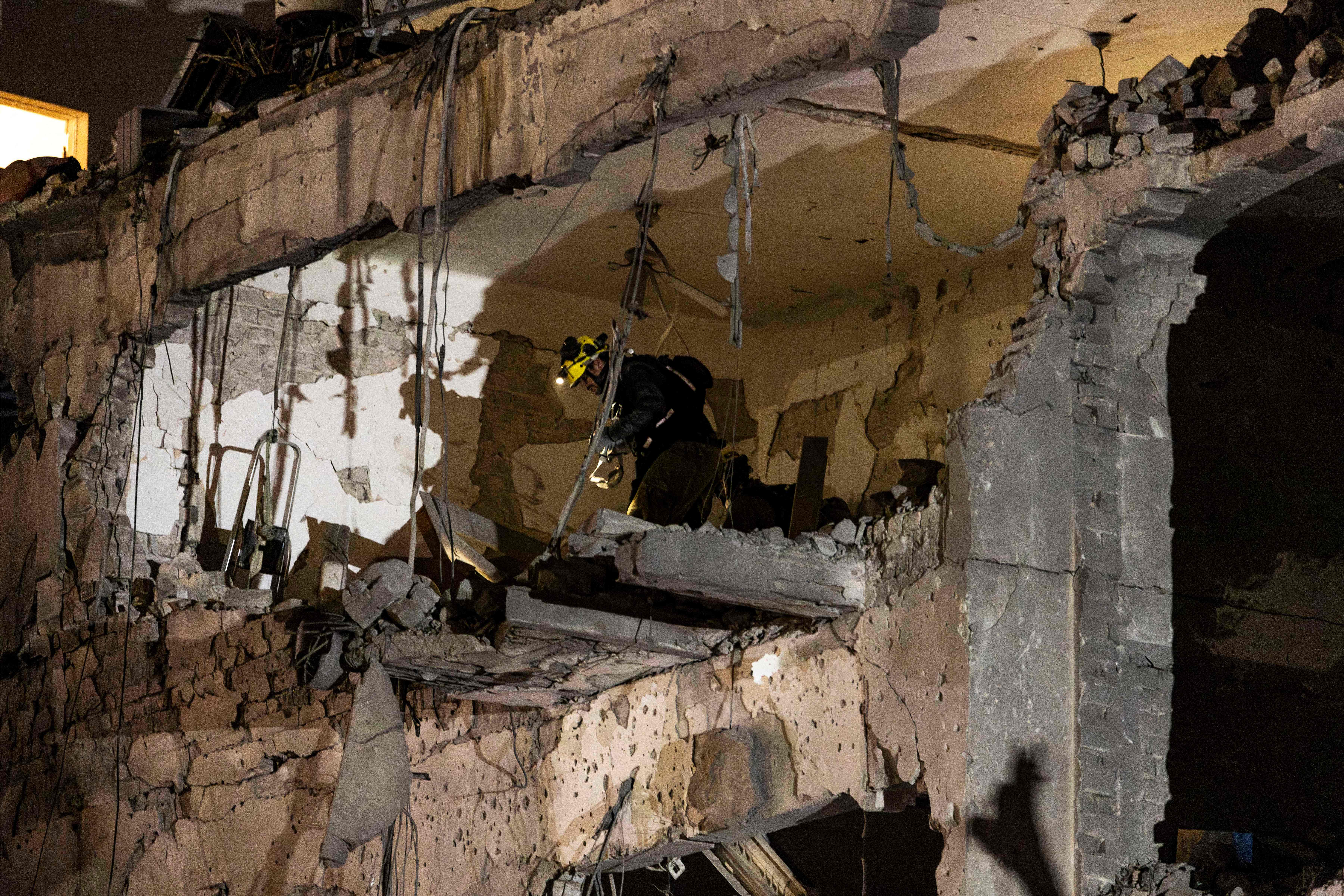 Israeli security forces inspect the site of an Iranian missile strike in Tel Aviv on February 28, 2026. The United States and Israel launched strikes against Iran on February 28, with Israel's public broadcaster reporting that the Iranian supreme leader had been targeted, as the Islamic republic retaliated with barrages of missiles at Gulf states and Israel. (Photo by JOHN WESSELS / AFP)