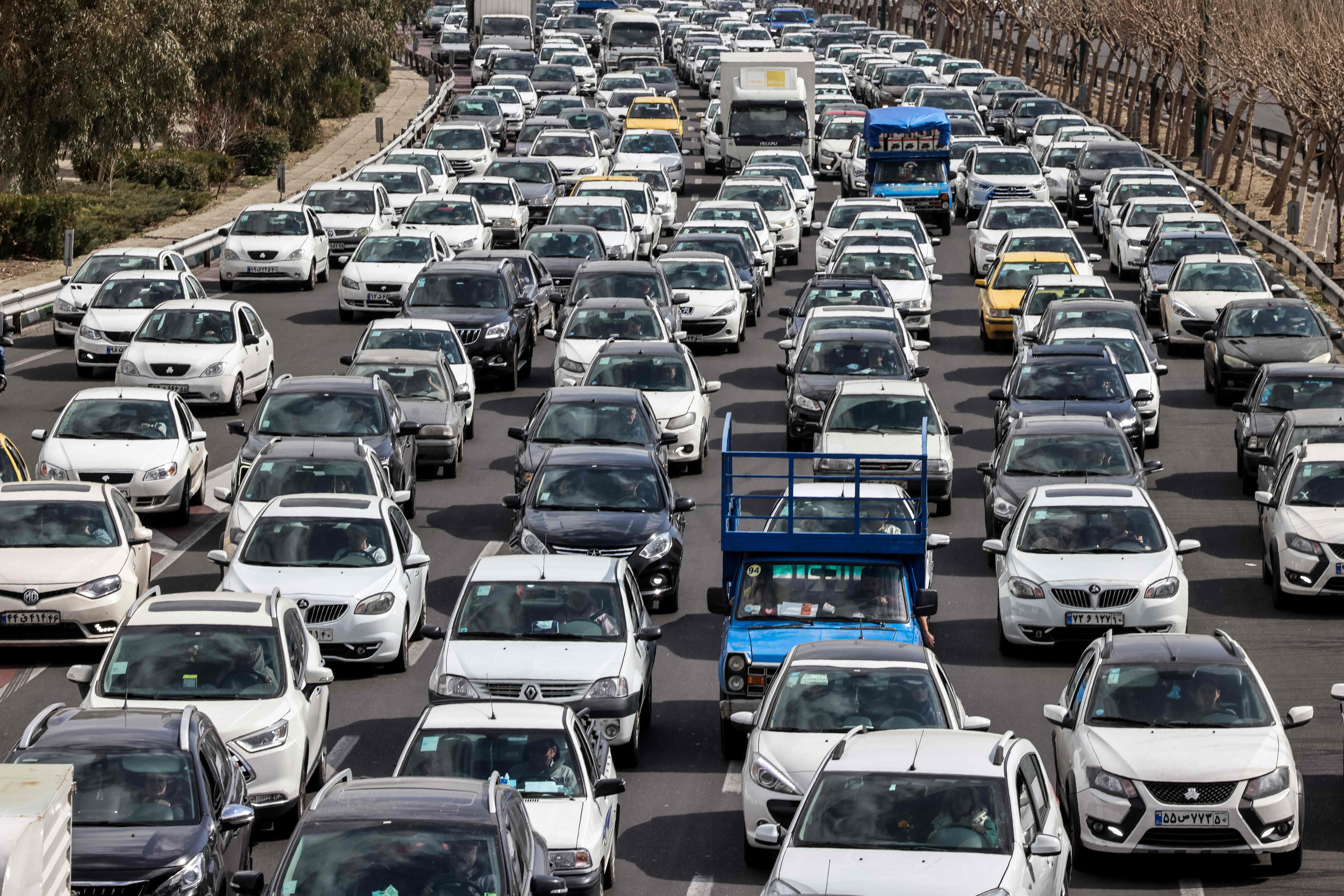 Conductores transitan por una calle en Teherán tras los ataques lanzados por Estados Unidos e Israel contra Irán mientras el país respondía con misiles hacia estados del Golfo e Israel.  (Foto Prensa Libre: AFP)