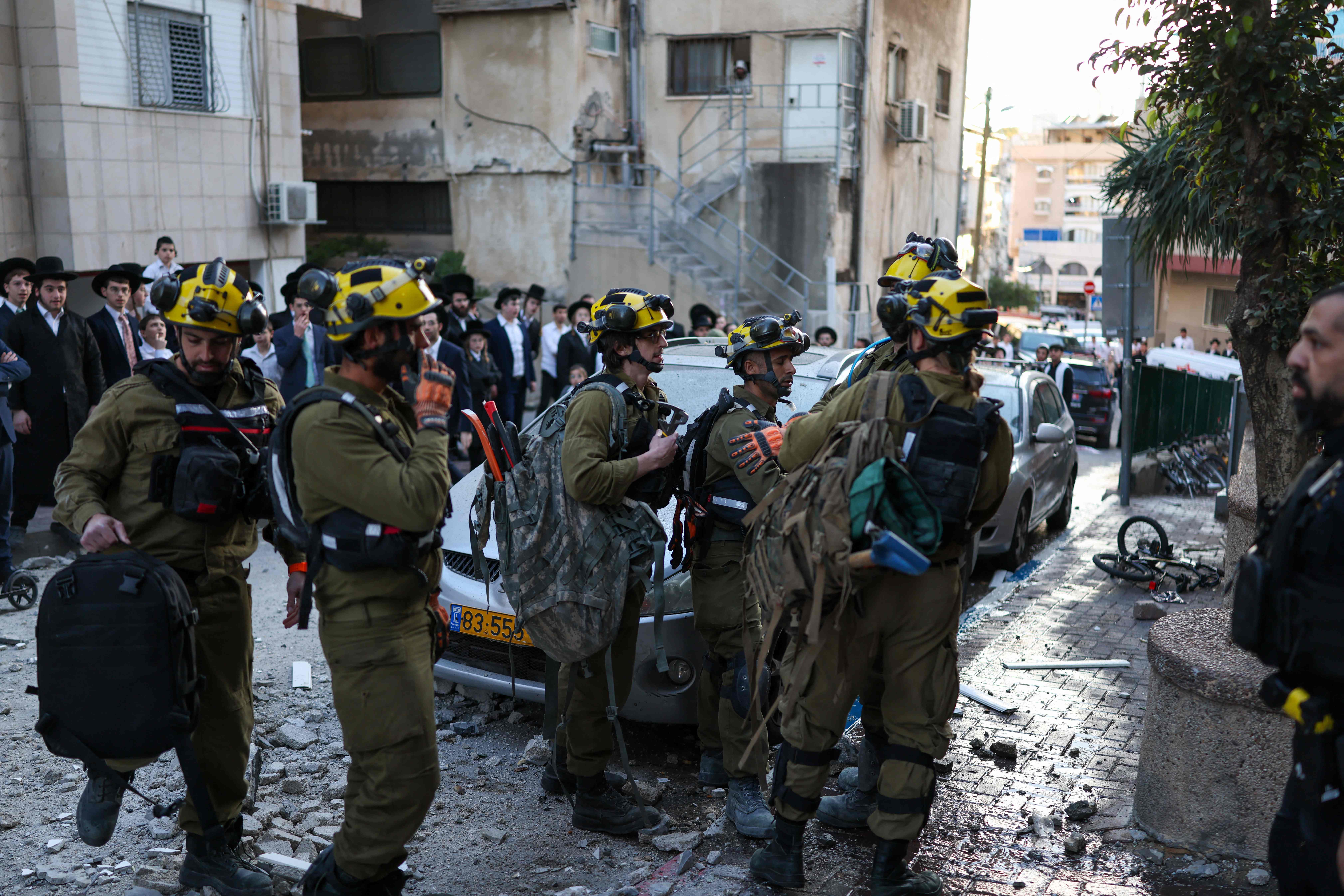 Socorristas israelíes llegan a un vecindario en las afueras de Tel Aviv donde cayeron restos tras la interceptación de un cohete en medio de los ataques.(Foto Prensa Libre: EFE)