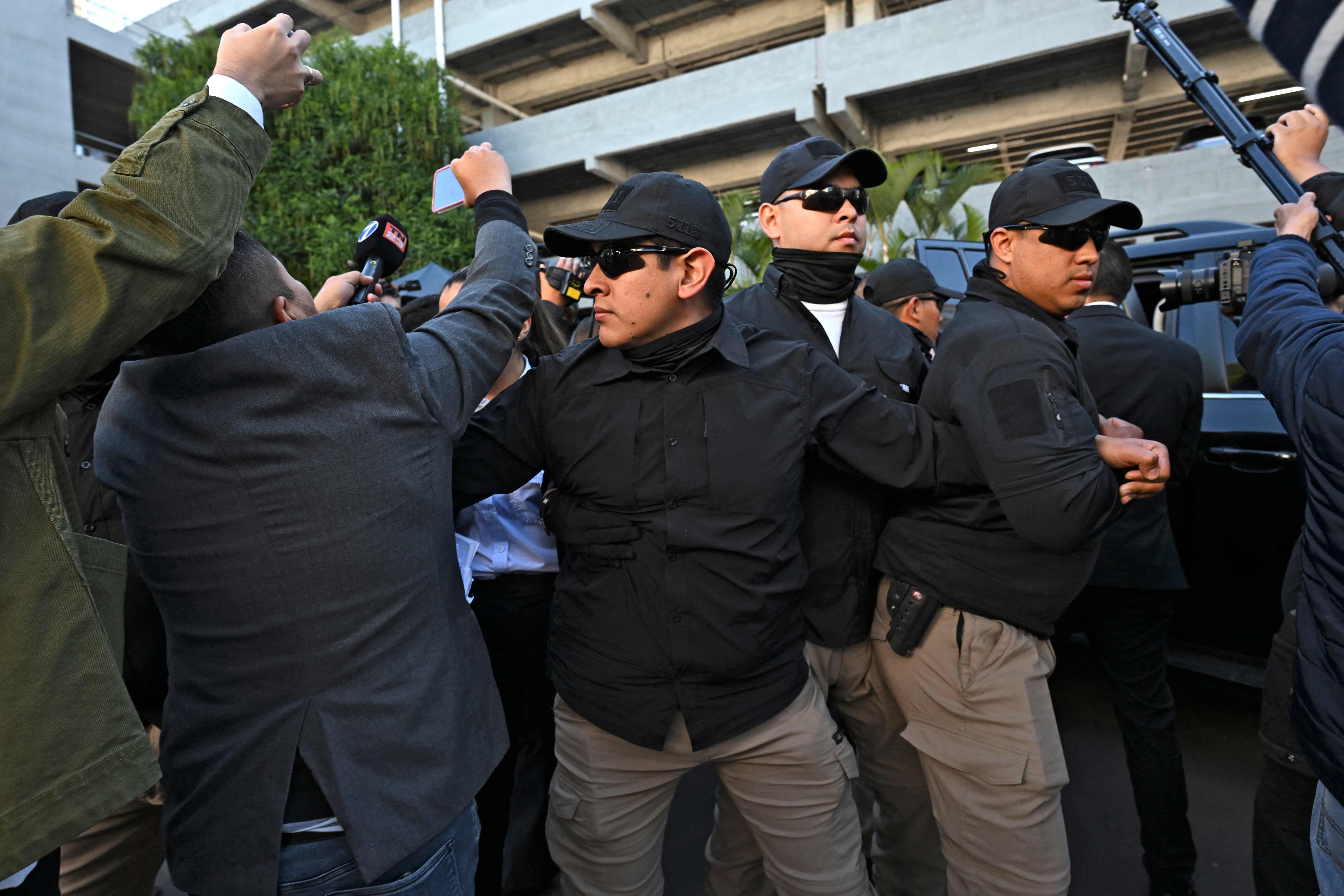 Los guardaespaldas protegen a la fiscal general de Guatemala, Consuelo Porras, durante la votación para elegir magistrados de la Corte de Constitucionalidad, en el Club la Aurora.( Foto Prensa Libre: AFP)