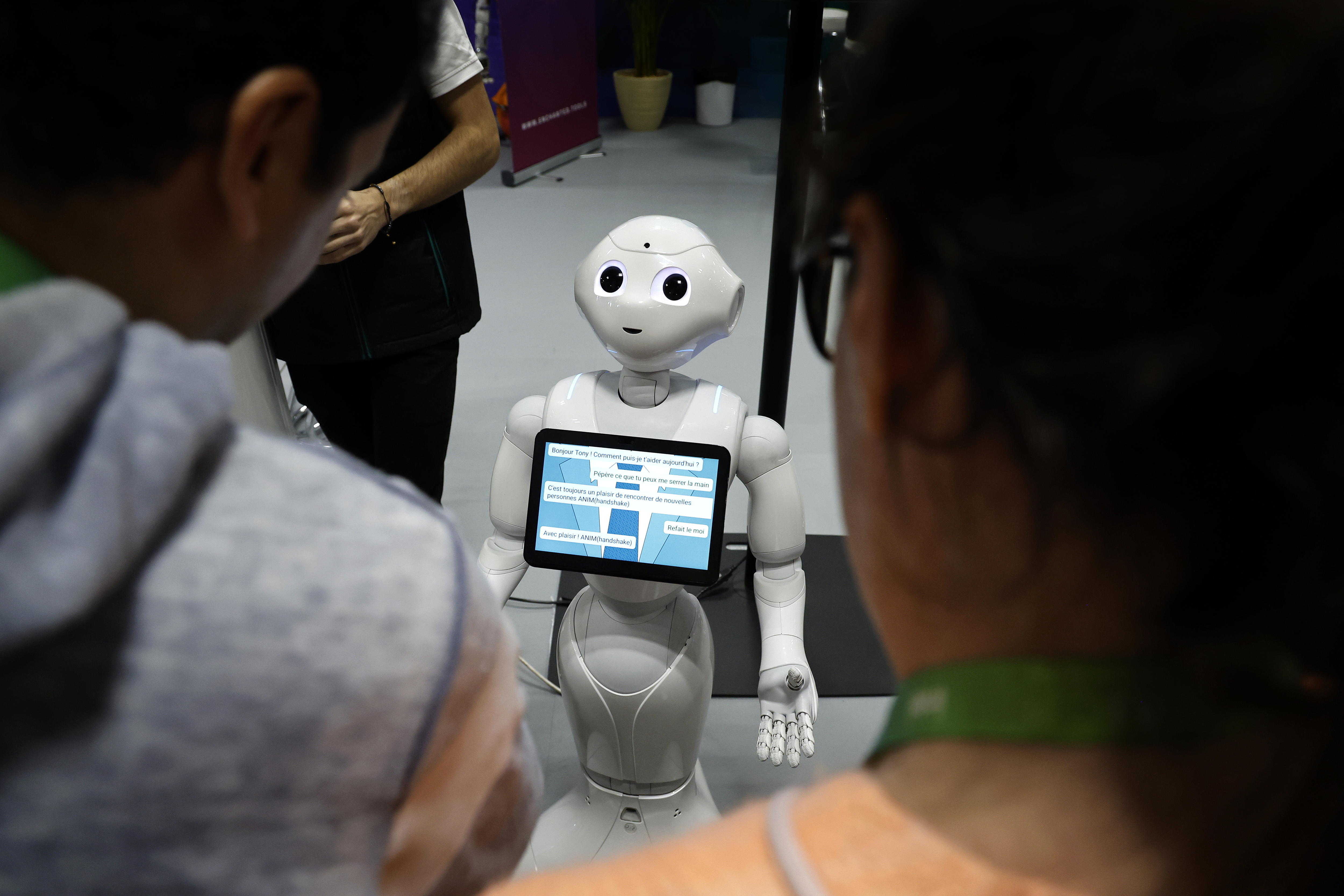 Unos visitantes hablan con el robot 'Pepper' en una imagen de archivo de una feria. EFE/EPA/SEBASTIEN NOGIER