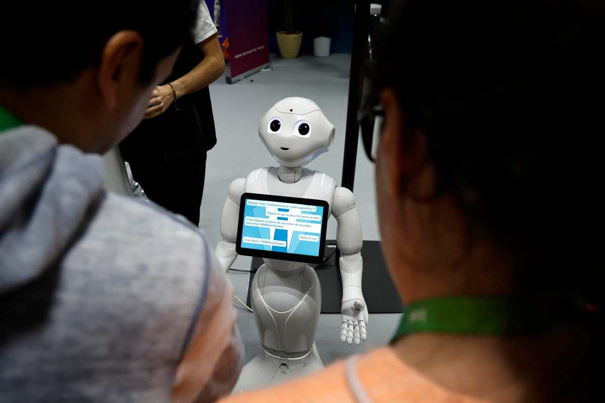 Unos visitantes hablan con el robot 'Pepper' en una imagen de archivo de una feria. EFE/EPA/SEBASTIEN NOGIER