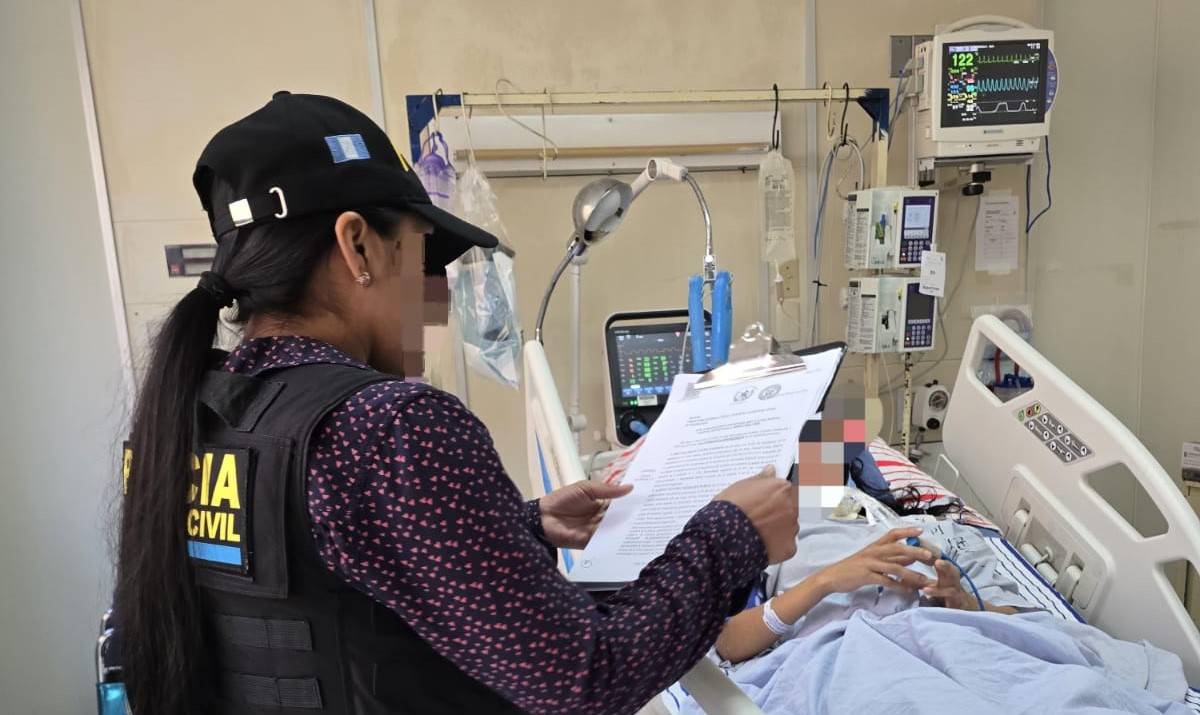 Una agente de la PNC custodia a la presunta sicaria en una cama del Hospital General San Juan de Dios, donde fue notificada de su captura por orden judicial. (Foto Prensa Libre: PNC) 