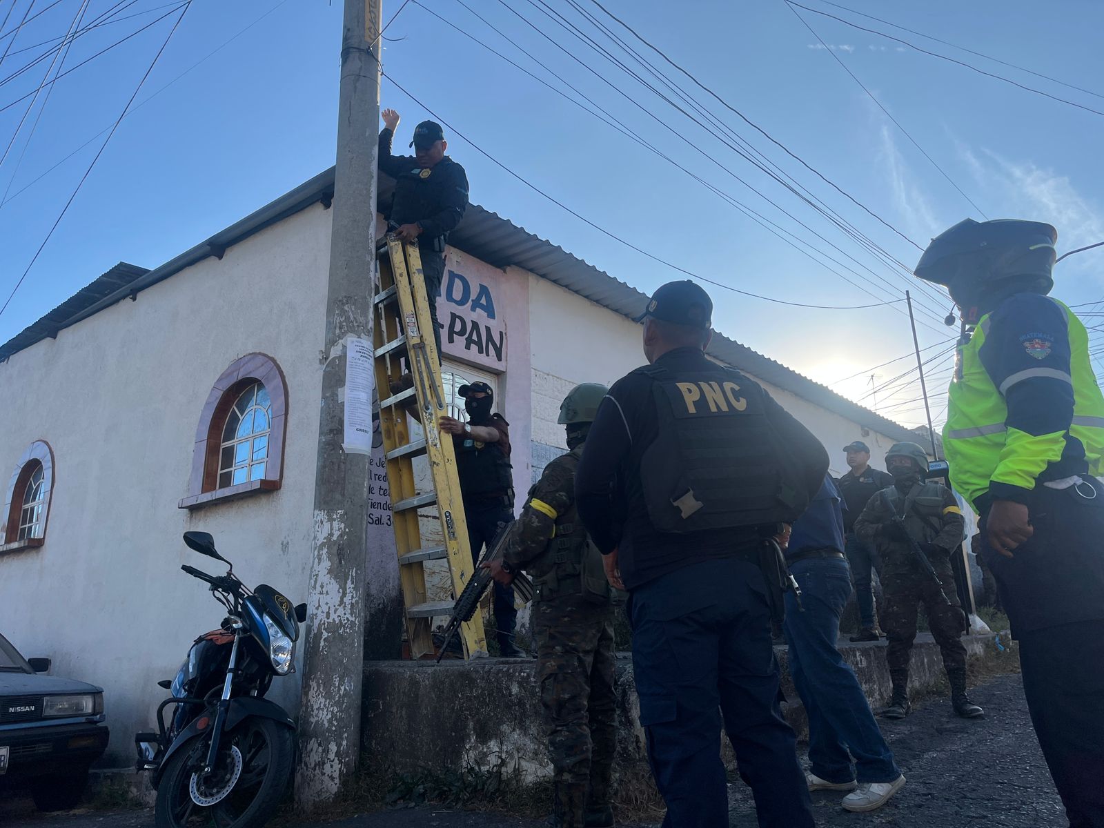 Agentes de la PNC retiran cámaras de videovigilancia instaladas por el Barrio 18 en postes de la colonia San Rafael II, zona 18. (Foto Prensa Libre: PNC)