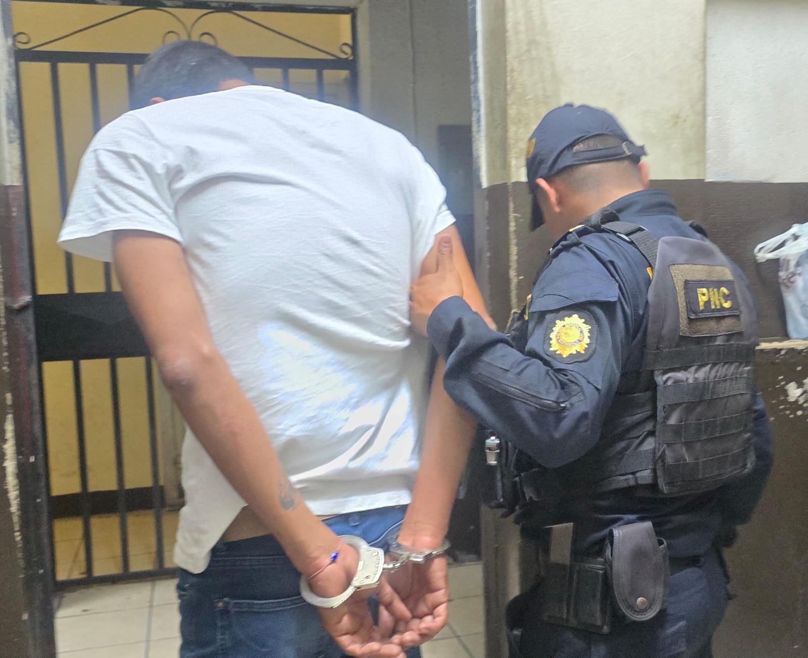 Un agente de la PNC traslada a Melvin “N” tras su captura en Escuintla, luego de que atropellara a cuatro personas, entre ellas dos policías. (Foto Prensa Libre: PNC)