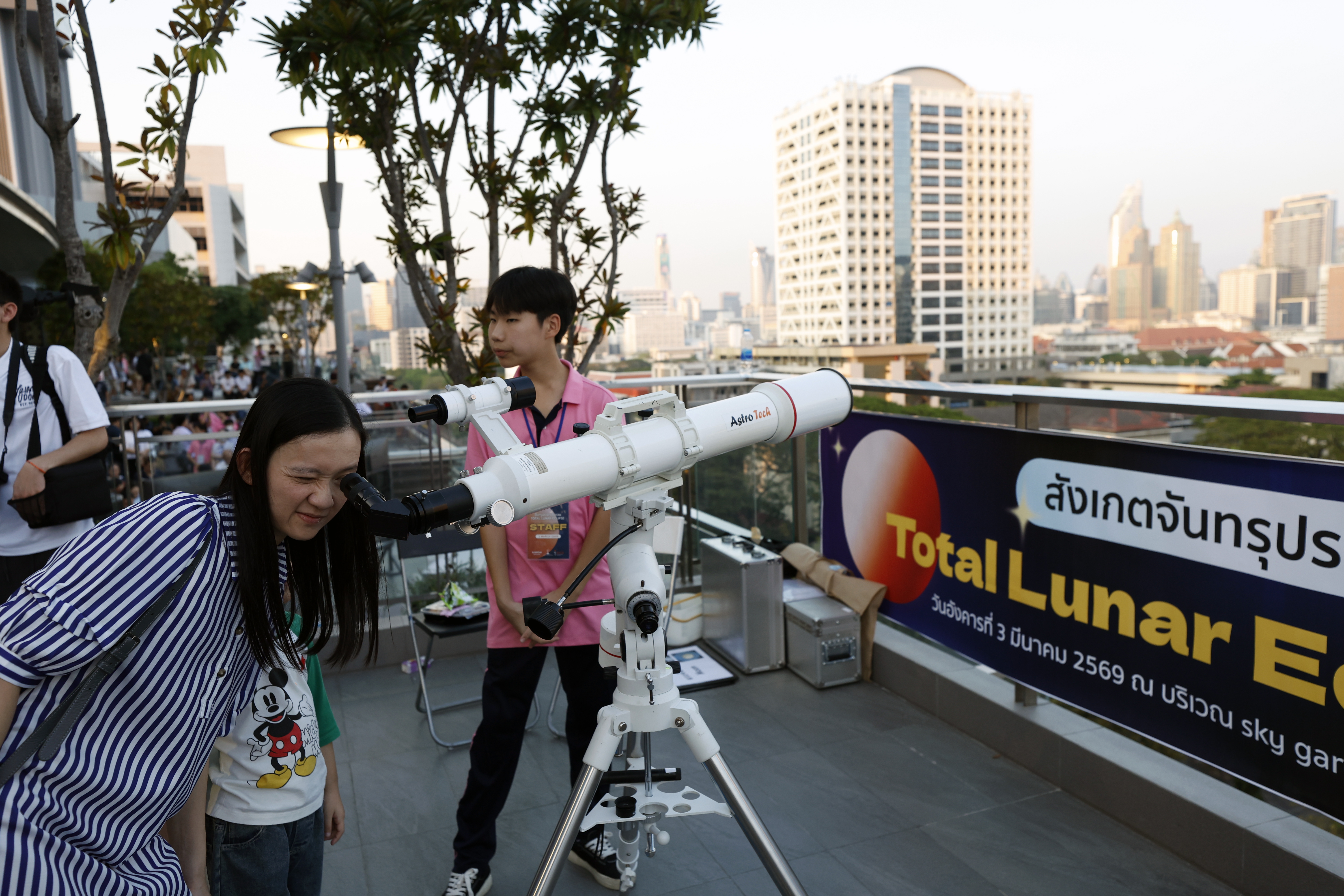 Una mujer tailandesa observa el cielo con un telescopio previo al eclipse lunar total durante un evento astronómico en Bangkok. (Foto Prensa Libre: EFE)