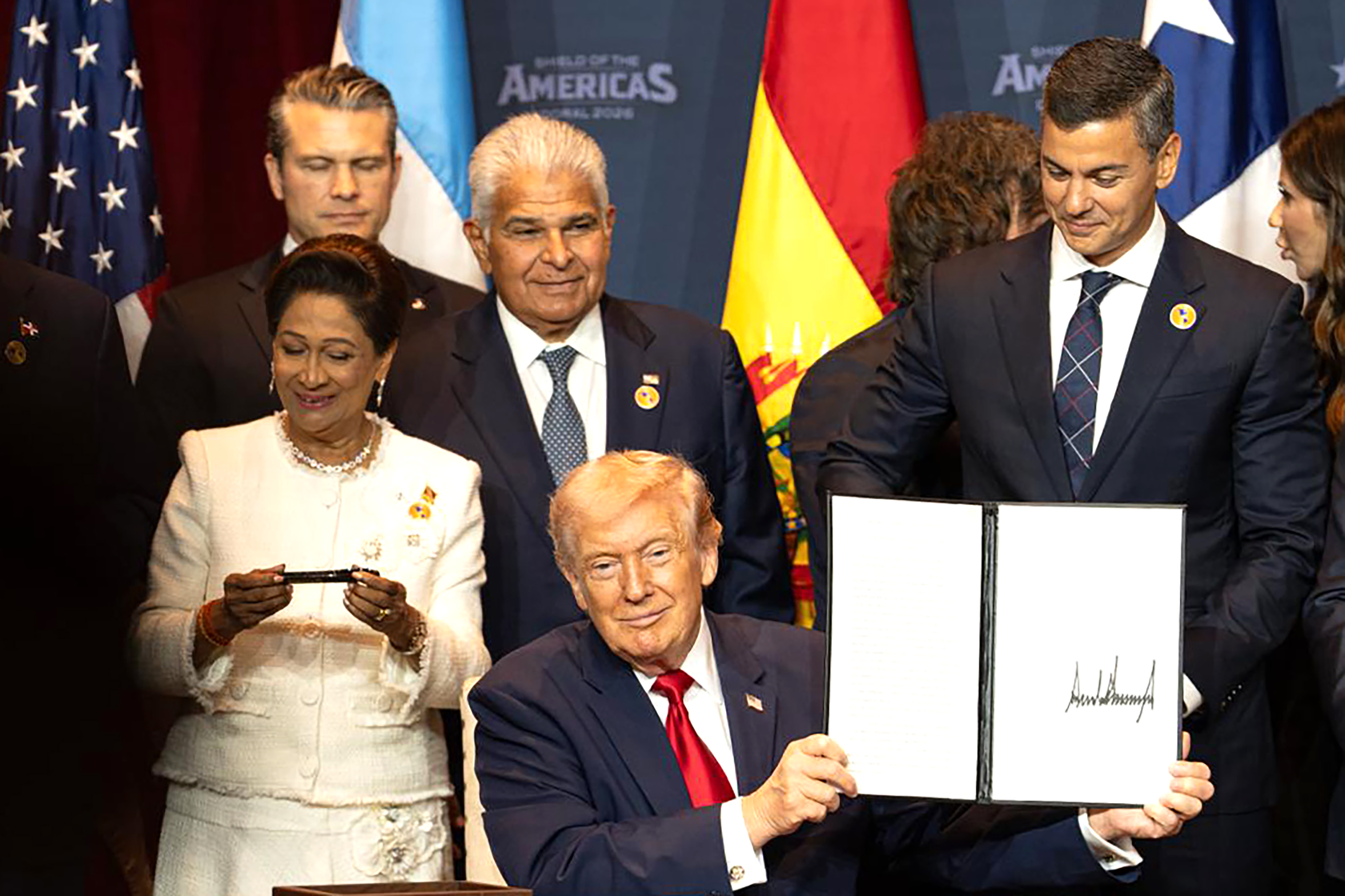 AME1495. MIAMI (ESTADOS UNIDOS), 07/03/2026.- Fotografía cedida por la Presidencia de Paraguay que muestra al presidente de Estados Unidos, Donald Trump (c), sosteniendo un documento junato al presidente de Paraguay, Santiago Peña (i), la primera ministra de Trinidad y Tobago, Kamla Persad-Bissessar (i), y el presidente de Panamá José Raúl Mulino (c-arriba), este sábado, en Miami (EE.UU.). Trump anunció una nueva "coalición militar" en Latinoamérica contra los carteles del narcotráfico, durante la cumbre 'Escudo de las Américas' con líderes de derecha de la región, a quienes dijo que necesita su "ayuda". EFE/ Presidencia de Paraguay /SOLO USO EDITORIAL/NO VENTAS/SOLO DISPONIBLE PARA ILUSTRAR LA NOTICIA QUE ACOMPAÑA (CRÉDITO OBLIGATORIO)