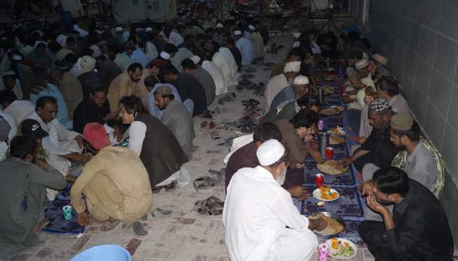DERA ISMAIL KHAN (Pakistan), 10/03/2026.- Muslims gather for the fast breaking meal Iftar, prepared by volunteers of Fixit Pakistan for poors and travelers in Dera Ismail Khan, Pakistan, 10 March 2026. Muslims all over the world are preparing to celebrate their biggest religious festival Eid al-Fitr which marks the end of the holy month of Ramadan and is expected to begin on 20 or 21 March 2026, depending on the lunar calendar. EFE/EPA/SAOOD REHMAN