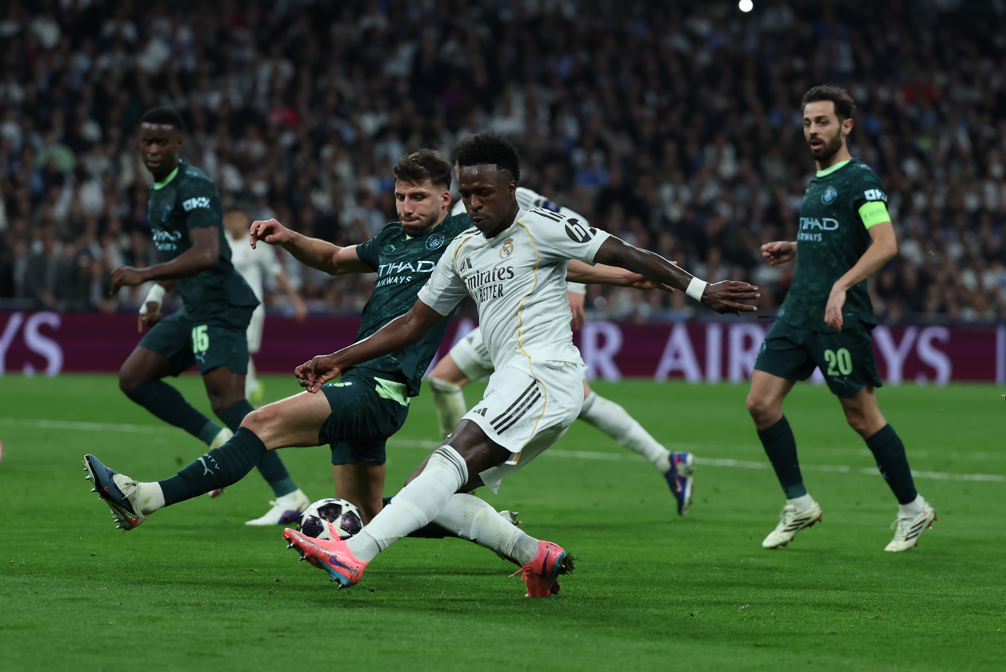 MADRID, 11/03/2026.- El delantero brasileño del Real Madrid, Vinicius Junior (d), golpea el balón ante el defensa portugués del Manchester City, Rubén Dias, durante el encuentro correspondiente a la ida de los octavos de final de la Liga de Campeones que Real Madrid y Manchester City disputan este miércoles en el estadio Santiago Bernabéu, en Madrid. EFE/Kiko Huesca.