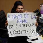 El diputado Francisco Lira muestra un letrero en el Congreso que ratificó reforma impulsada por Nayib Bukele con cadena perpetua. (Foto Prensa Libre: EFE)