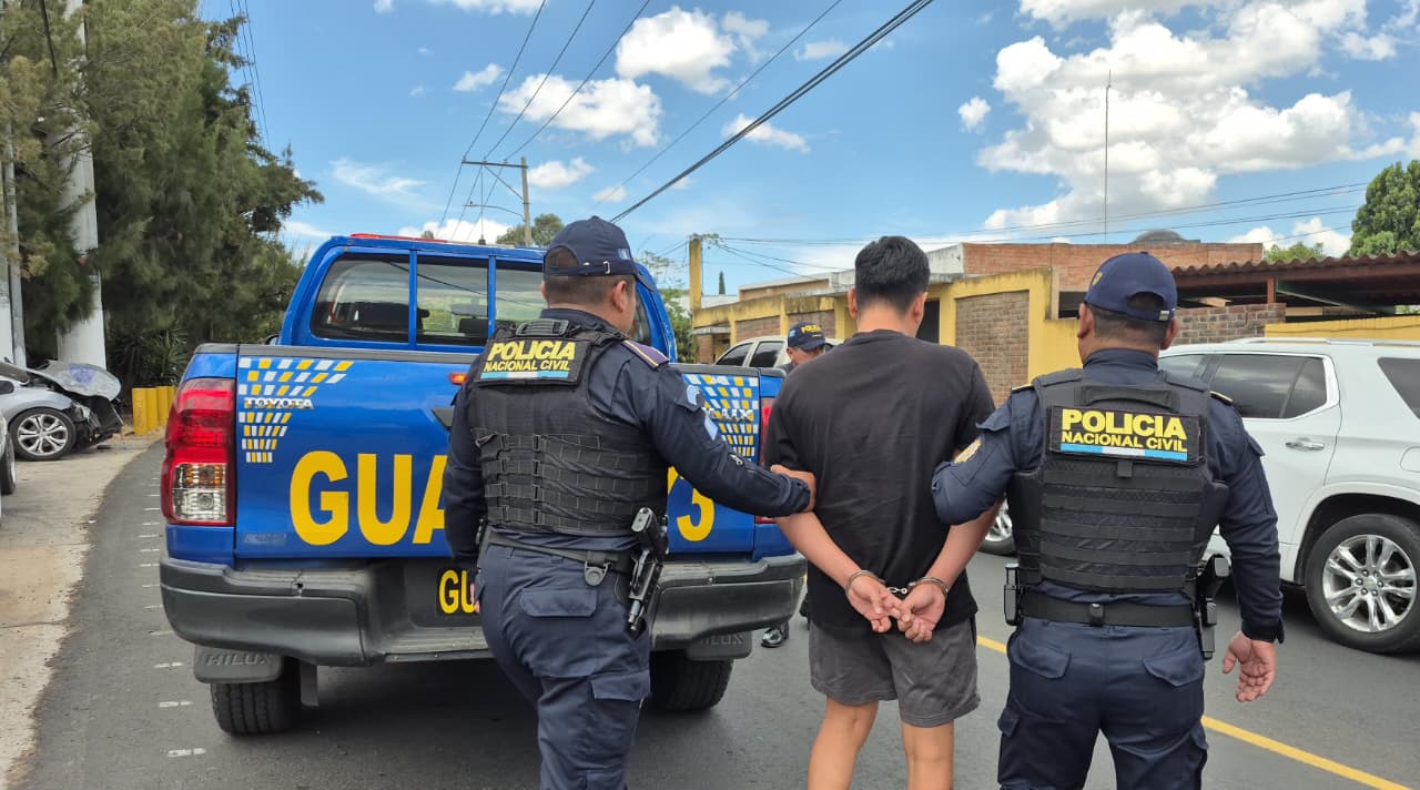 Agentes de la comisaría 16 trasladan al presunto pandillero Kilder “R”, hermano de alias  “El Inquieto”, luego de su captura en Mixco. (Foto Prensa Libre: PNC)