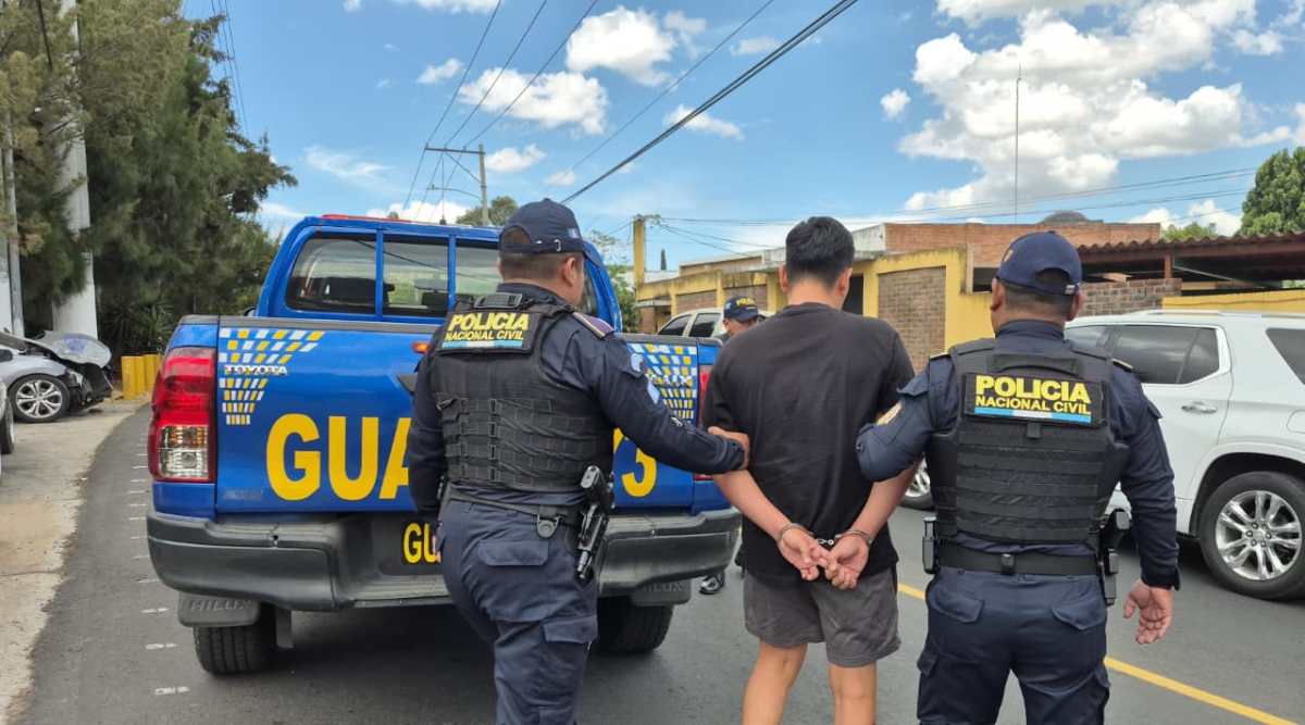 Agentes de la comisaría 16 trasladan al presunto pandillero Kilder “R”, hermano de alias “El Inquieto”, luego de su captura en Mixco. (Foto Prensa Libre: PNC)