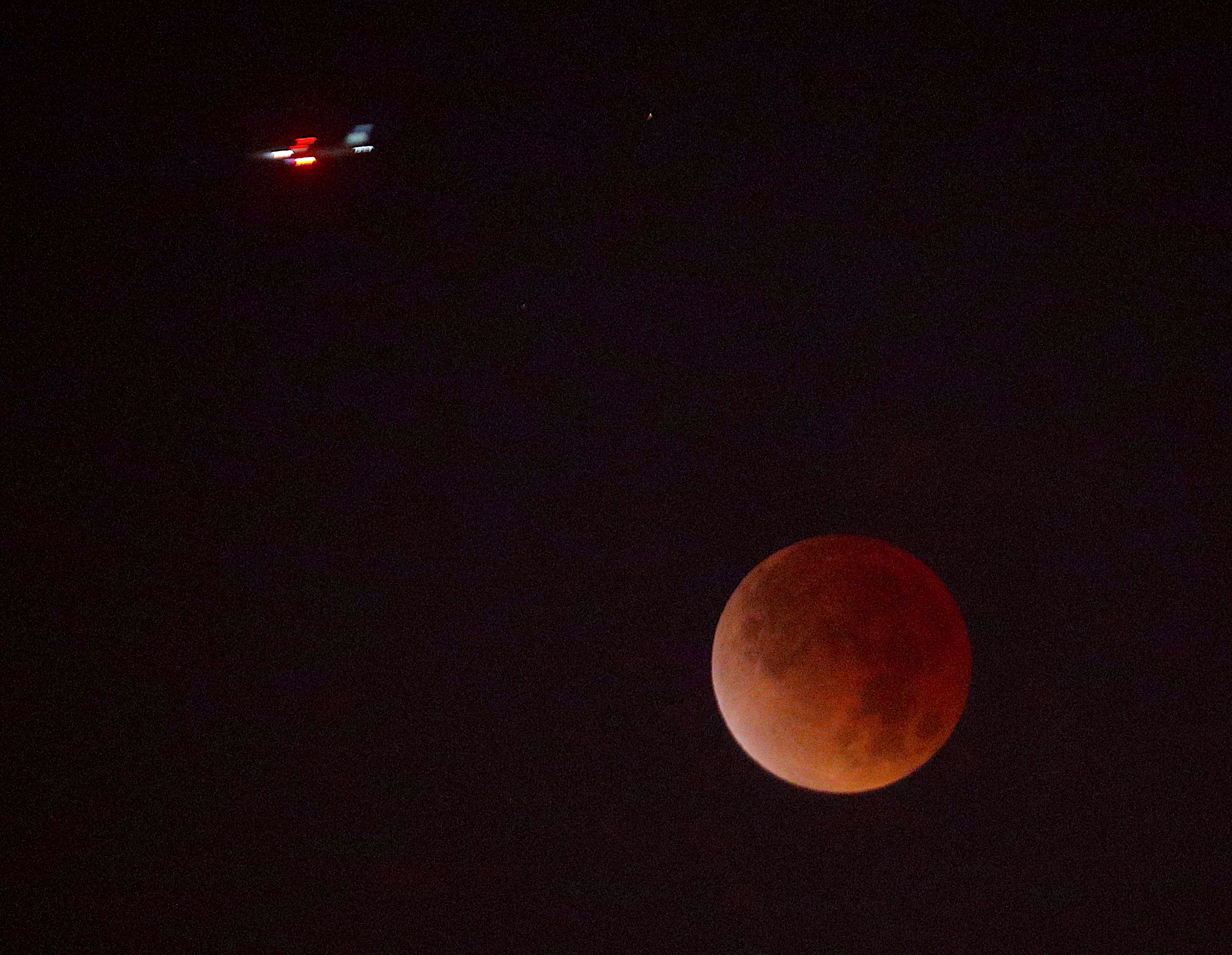 Un avión cruza frente a la Luna durante el eclipse lunar observado desde el edificio de Prensa Libre en la ciudad de Guatemala. (Foto Prensa Libre: Byron Rivera Baiza)