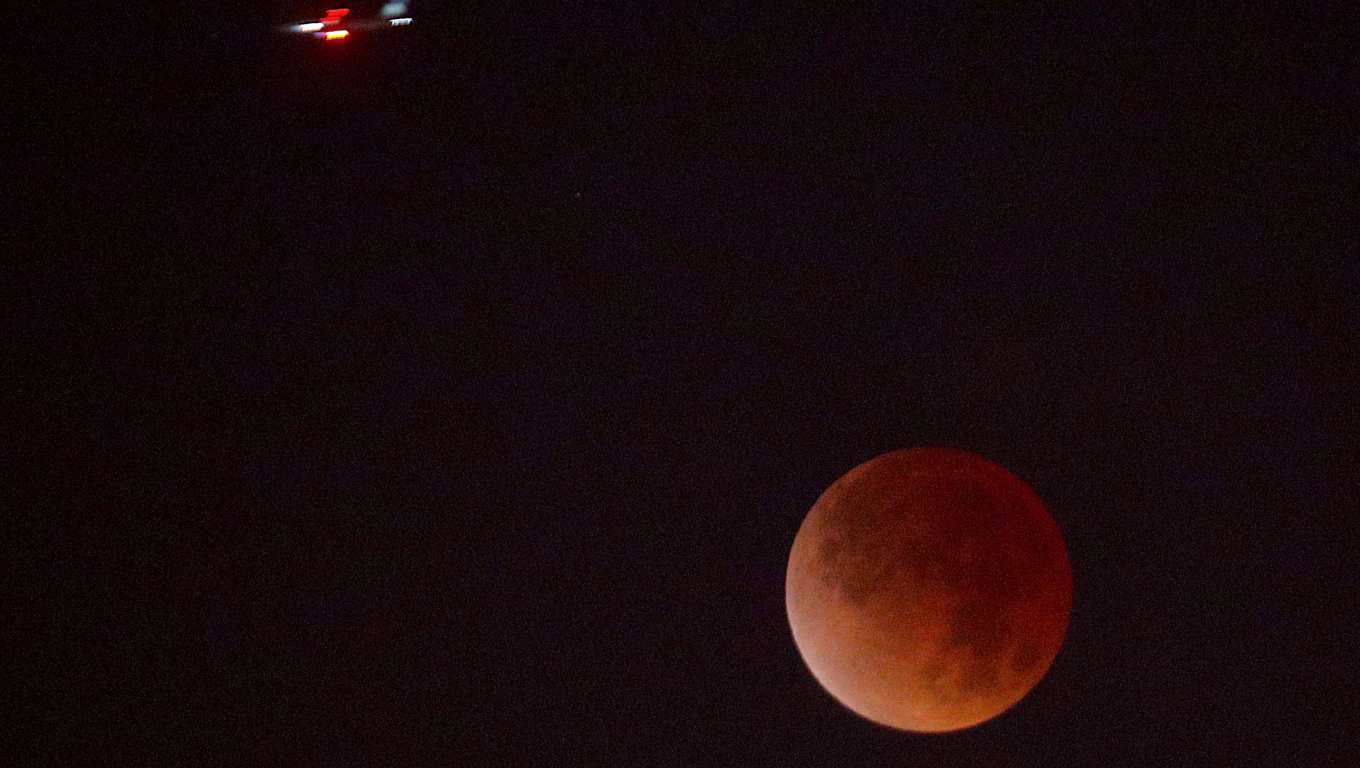 Un avión cruza frente a la Luna durante el eclipse lunar observado desde el edificio de Prensa Libre en la ciudad de Guatemala. (Foto Prensa Libre: Byron Rivera Baiza)