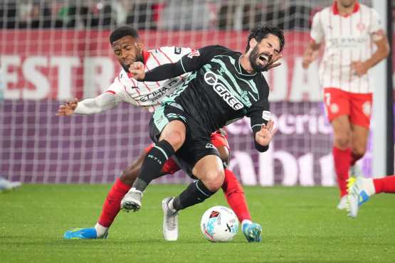 GIRONA (CATALUÑA), 21/04/2026.- El centrocampista del Betis Isco (d) cae ante el jugador francés del Girona, Thomas Lemar, durante el partido de la jornada 33 de LaLiga que Girona FC y Real Betis disputan este martes en el estadio de Montilivi. EFE/ David Borrat