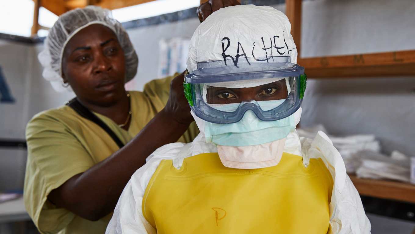 Un trabajador sanitario se viste con ropa protectora médica en un centro de tránsito para pacientes con ébola en Beni, provincia de Kivu del Norte, República Democrática del Congo. (Foto Prensa Libre: EFE)