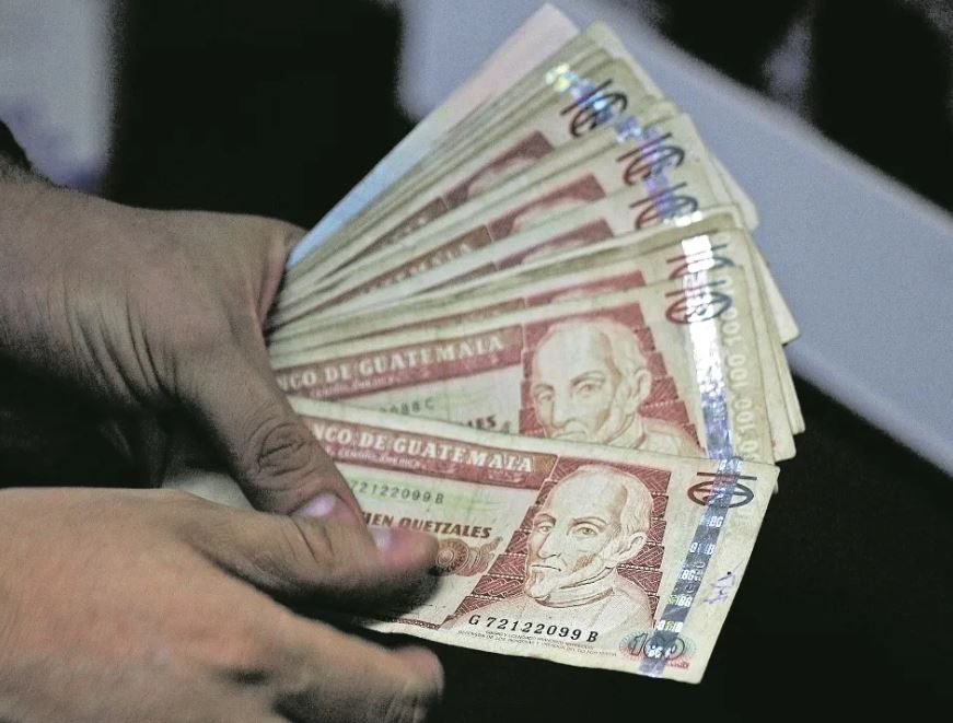 Billetes quetzales de 100 persona sosteniendo billetes bonos del tesoro