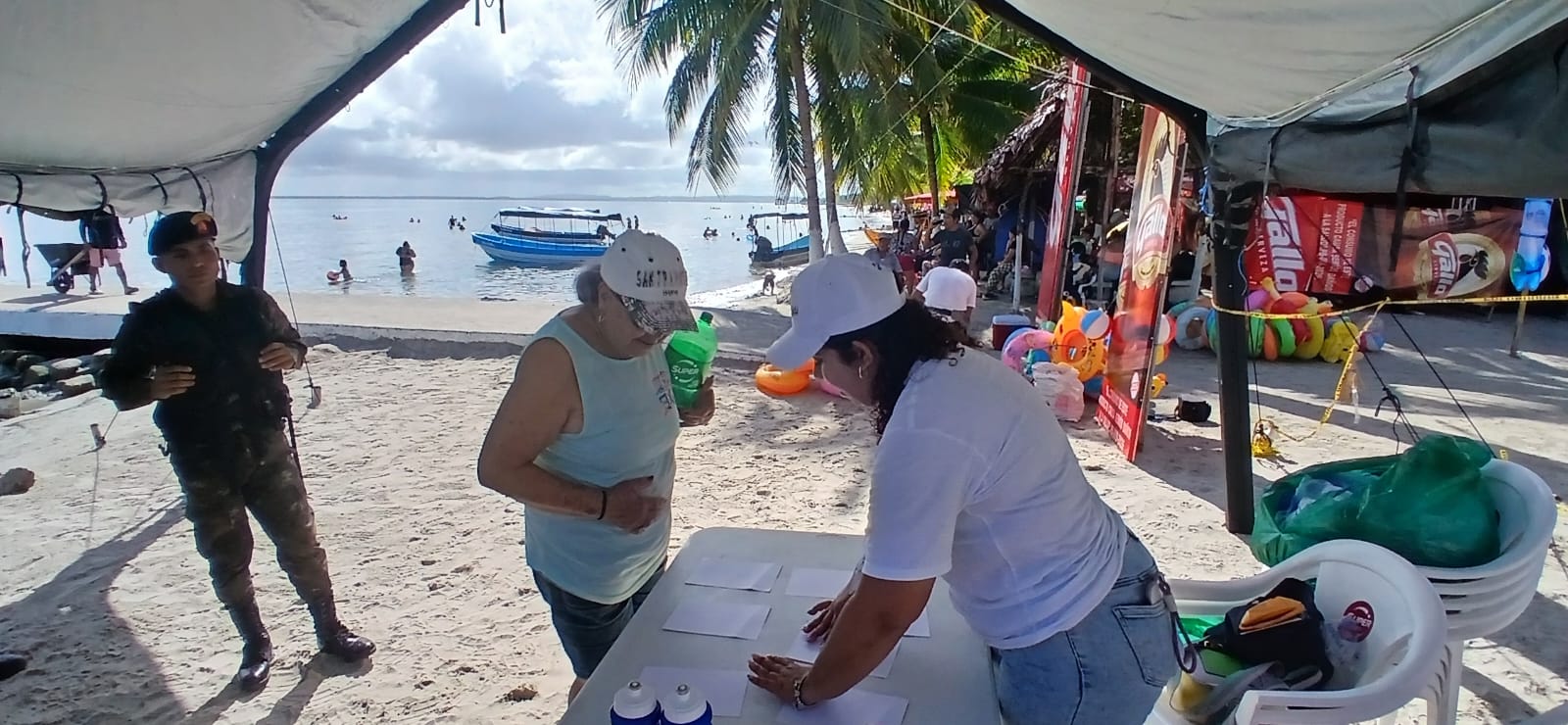 Personal de Sinaprese atiende a visitantes en un quiosco de información instalado en una playa del país. (Foto Prensa Libre: Conred)