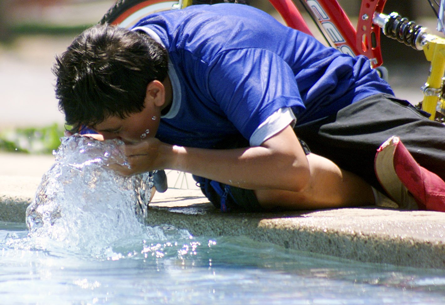 Ola de calor con temperaturas maximas en distintas regiones del Guatemala. Un joven se refresca en una fuente en la avenida las americas