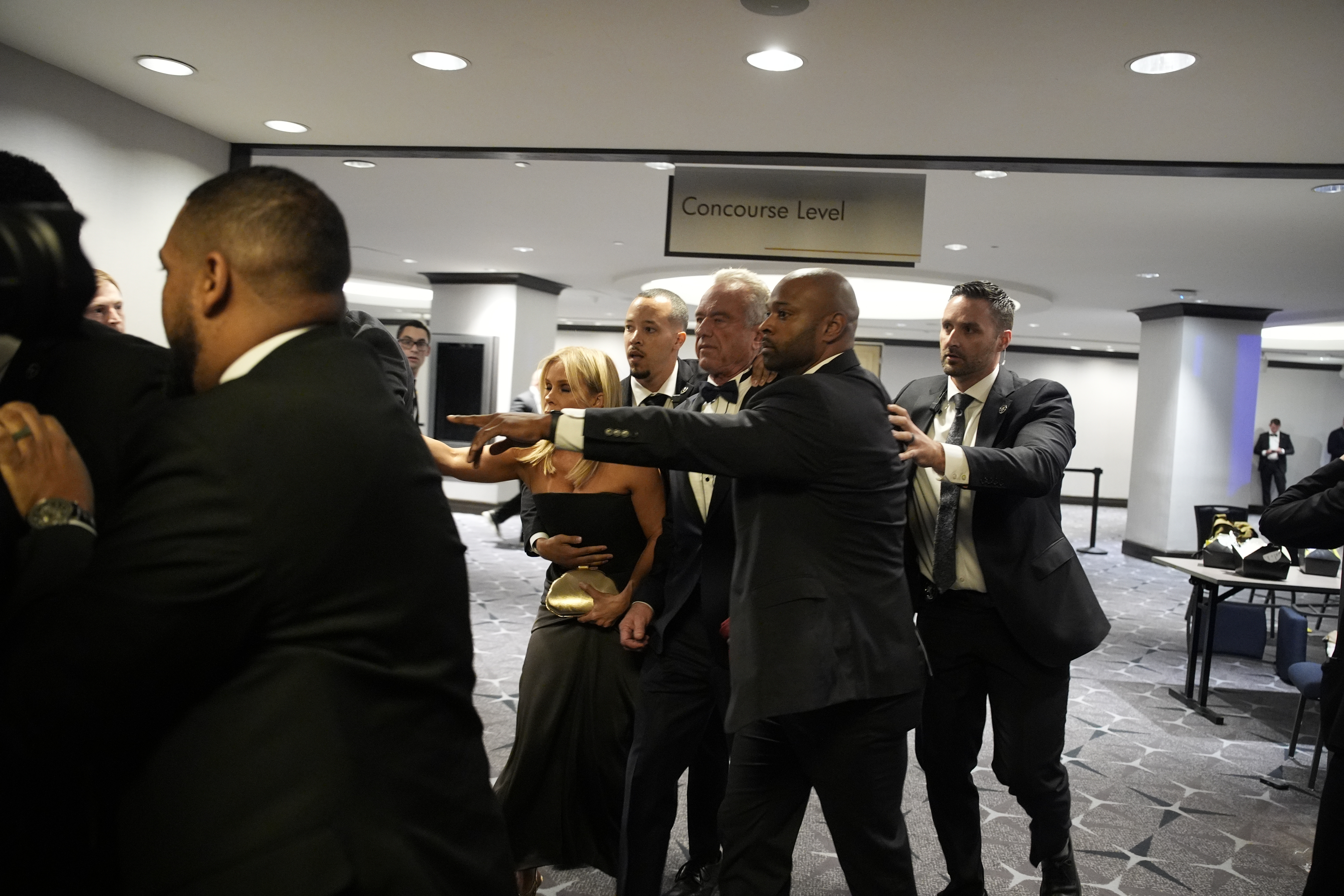 El secretario de Salud y Servicios Humanos, Robert Kennedy Jr., es evacuado por agentes del orden durante la cena de la Asociación de Corresponsales de la Casa Blanca en el hotel Washington Hilton en Washington, D.C. Estados Unidos. (Foto Prensa Libre: EFE).'