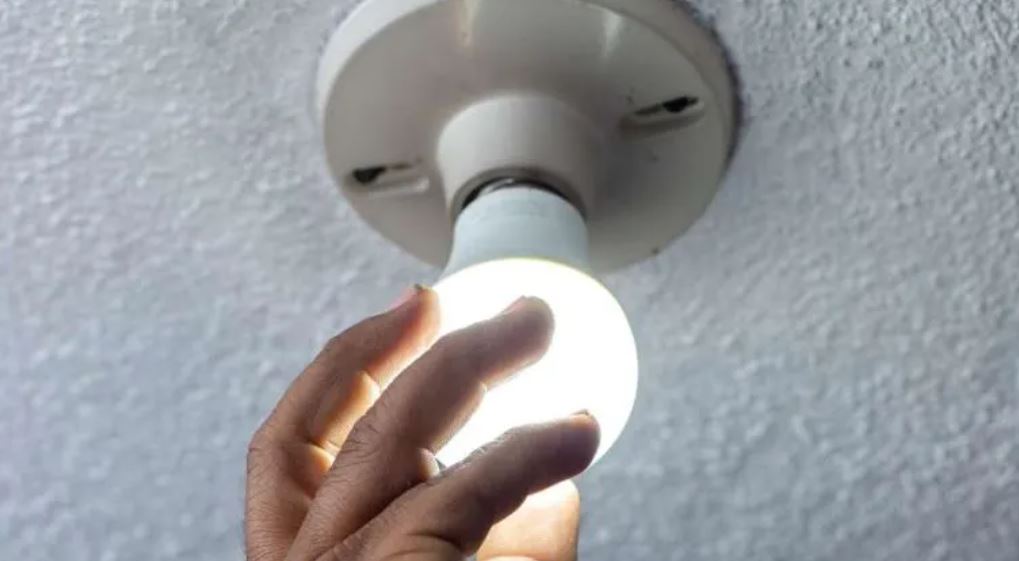 energía persona colocando un foco electricidad