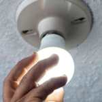 energía persona colocando un foco electricidad